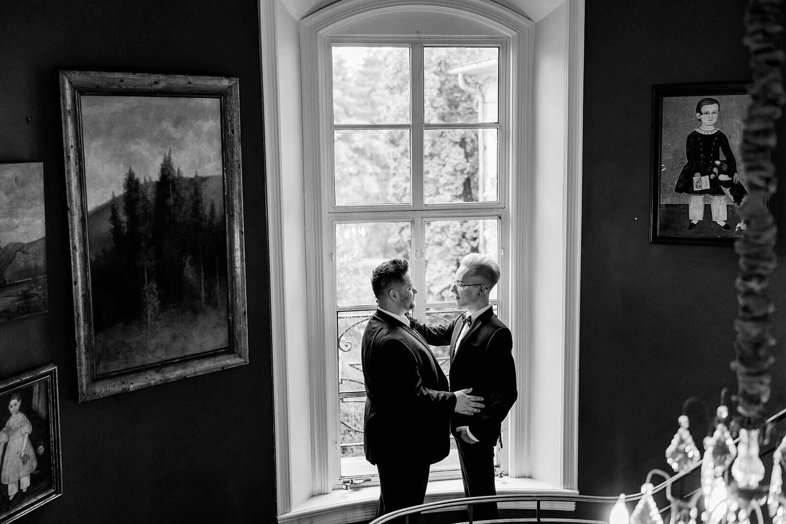 two grooms in front of the window Greencrest Manor wedding