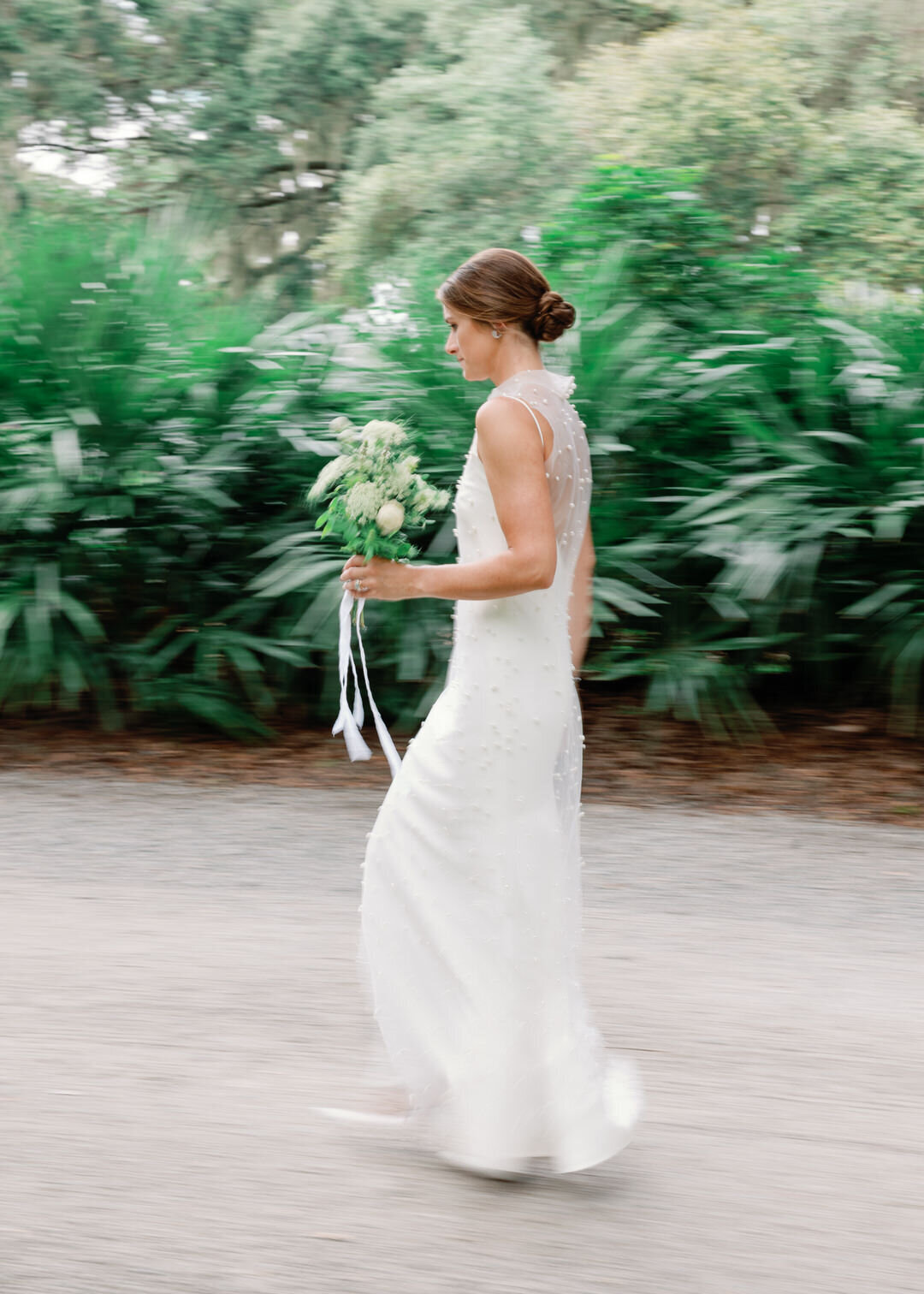 motion blur of bride walking by holding flowers