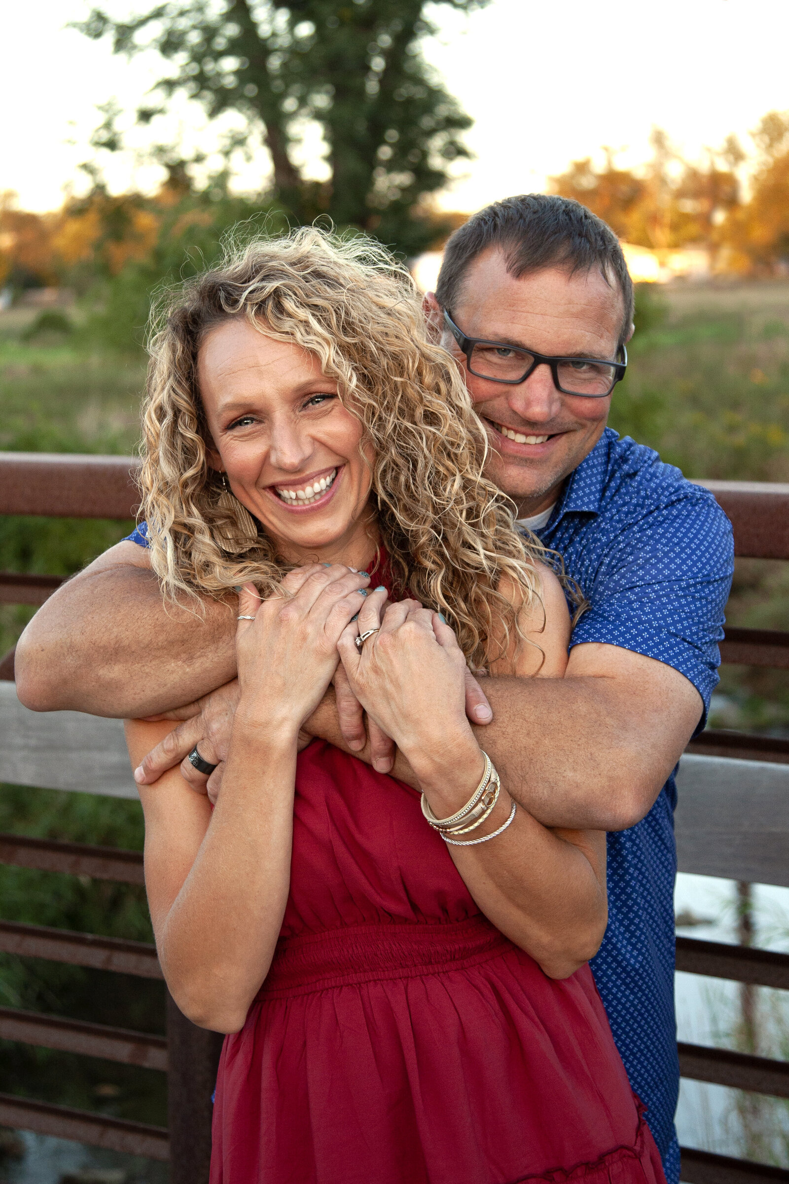 husband hugging wife around the shoulders, both smiling.