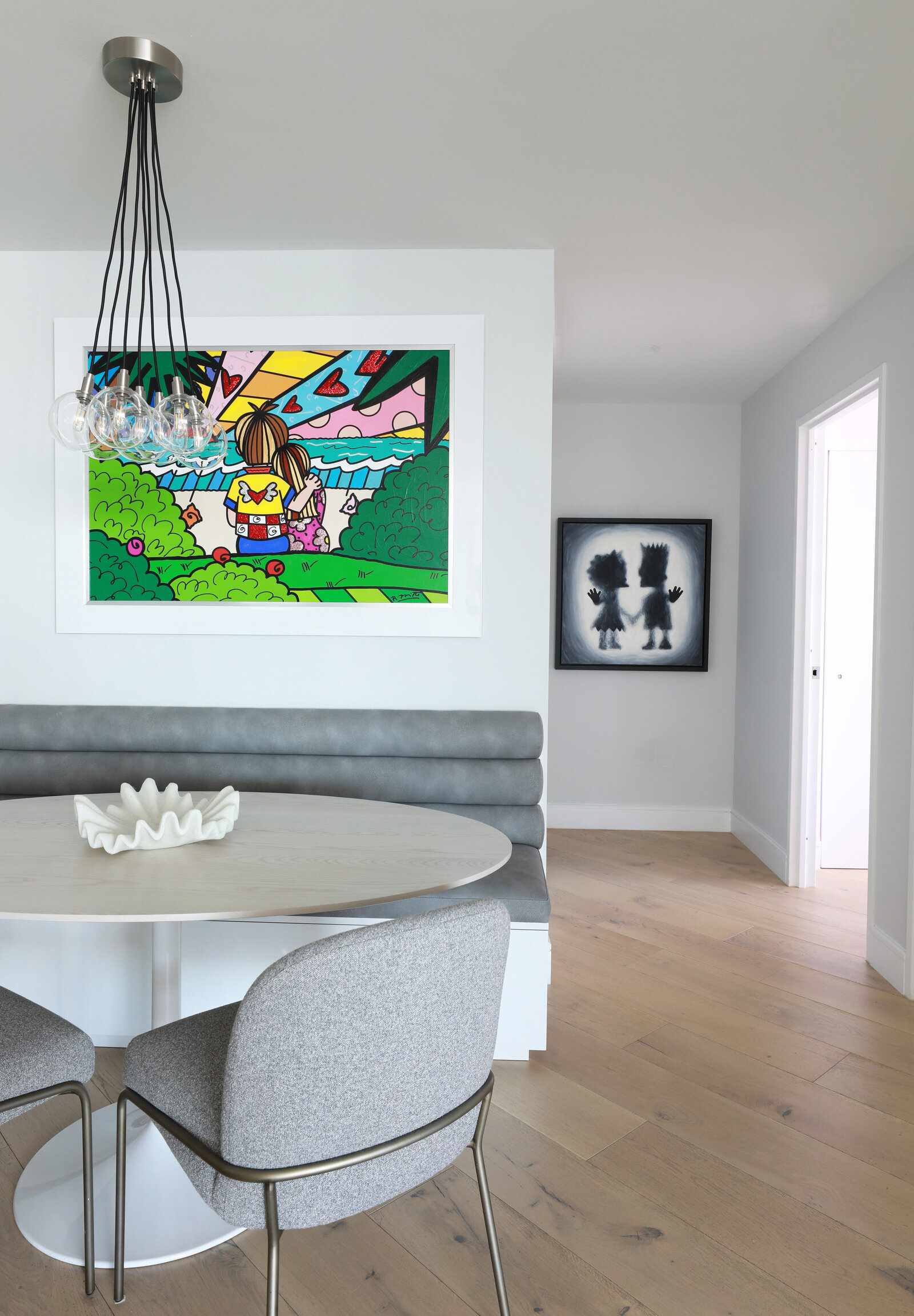 KITCHEN WITH BUILT IN BANQUETTE AND OVAL TABLE FUN ART