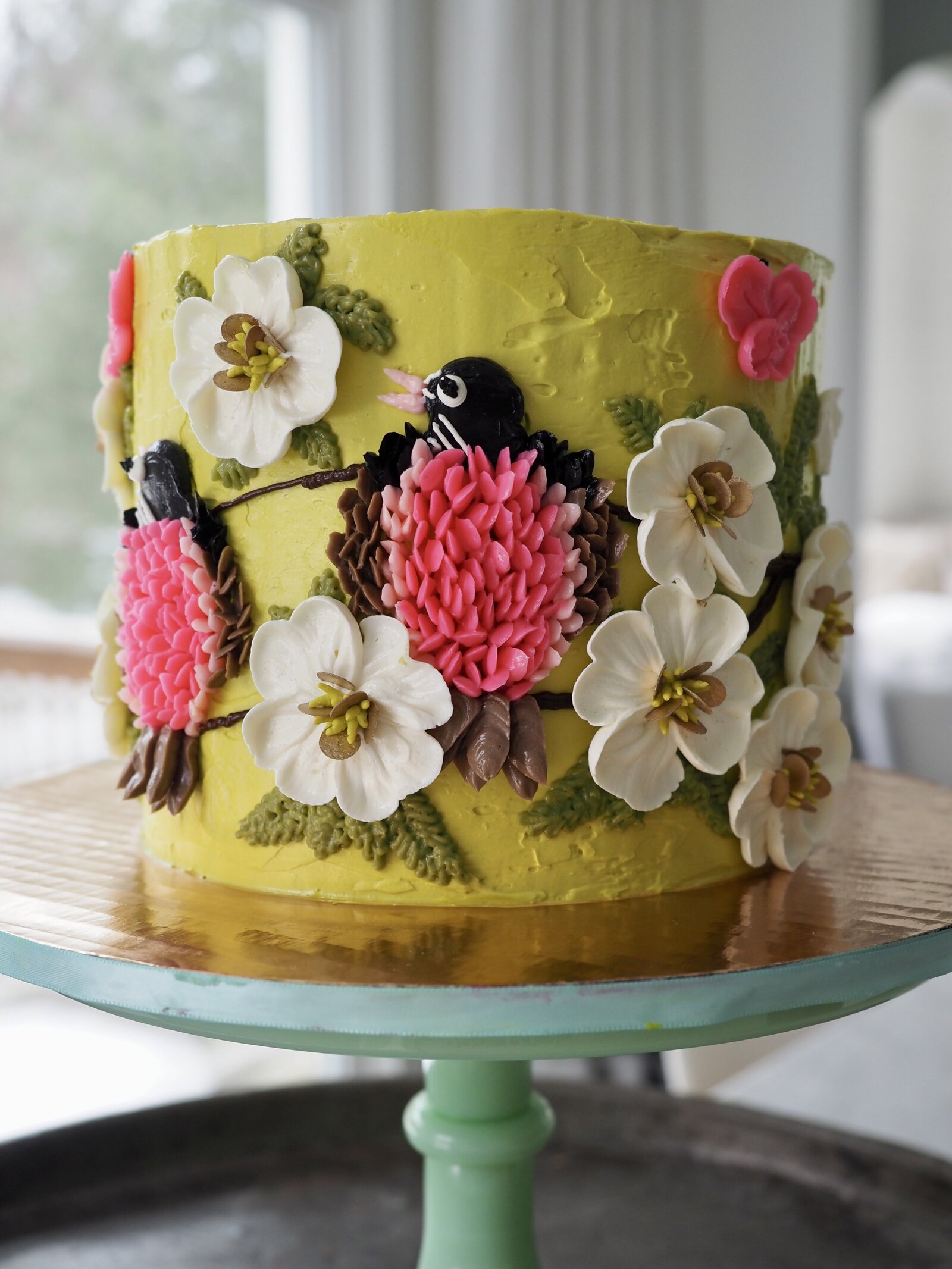 Buttercream cake with hand piped birds and flowers