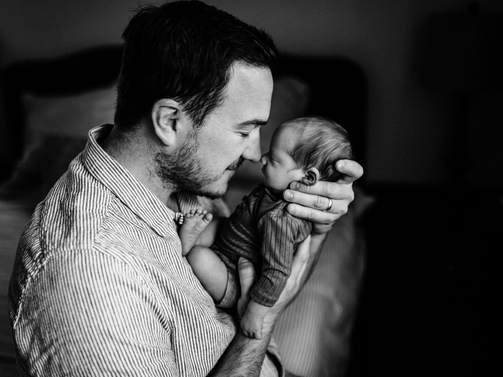dad holding newborn baby boy nose to nose for in home lifestyle newborn session