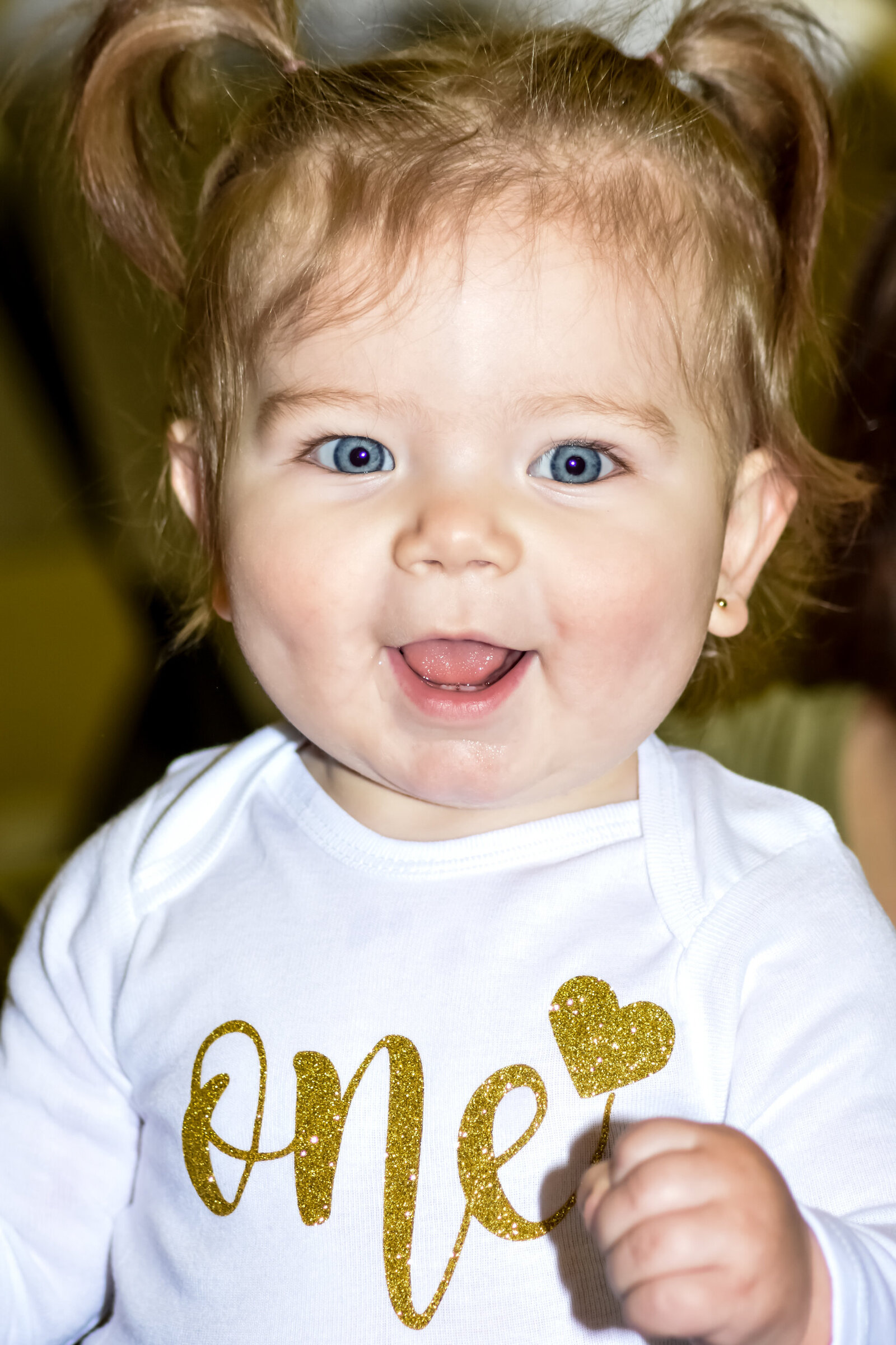 young girl smiling for the camera with a shirt that says one on her first birthday photographed by Millz Photography in Greenville, SC