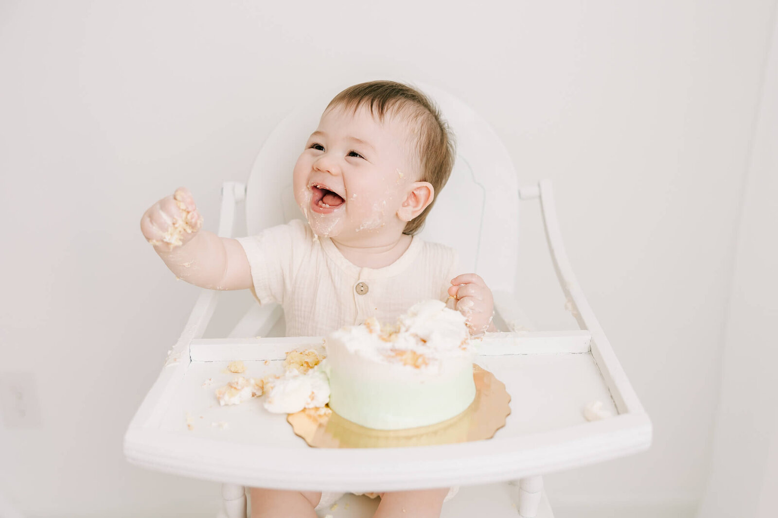 Captured big smiles from this 1 year old boy while he enjoys his cake during  milestone session with Molly Berry Photography.