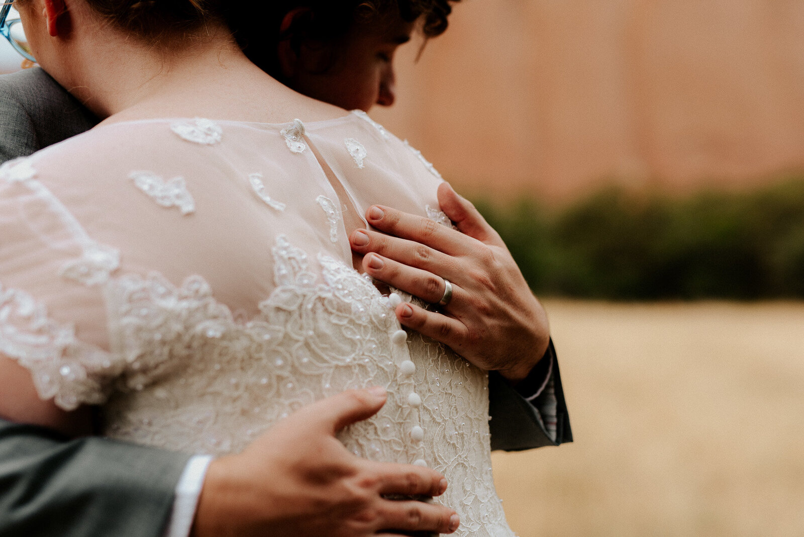 bride and groom holding each other at their wedding in roxborough park colorado.