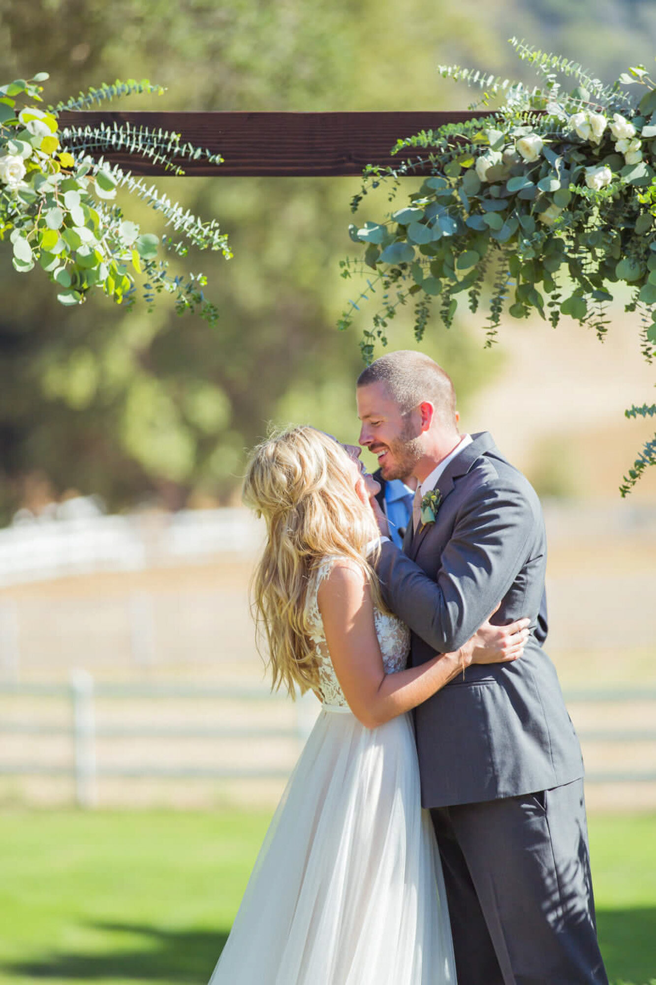 Groom about to kiss the bride, and smiling at each other