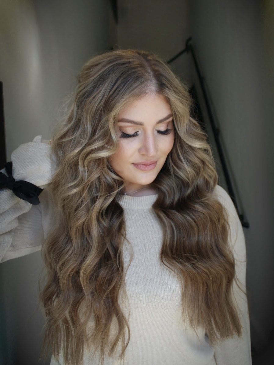 Elegant woman with natural beige-blonde waves looking downward