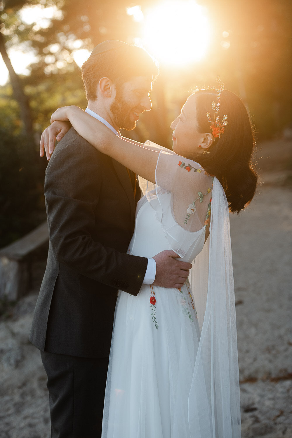 bide and groom embrace in golden sun