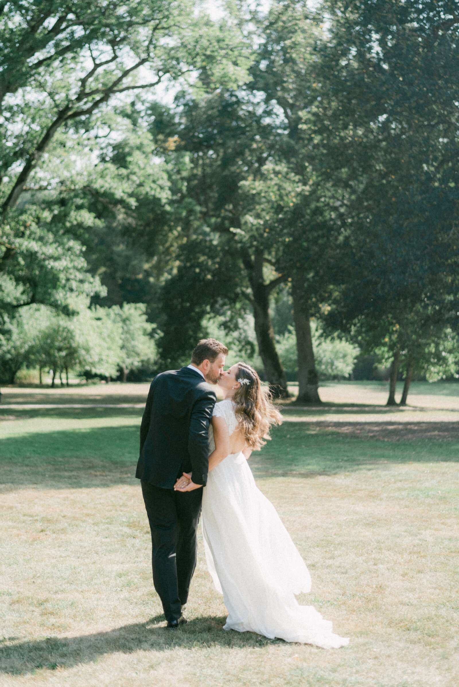 A wedding couple kissing and walking in a park in their wedding photography session with wedding photographer Hannika Gabrielsson.