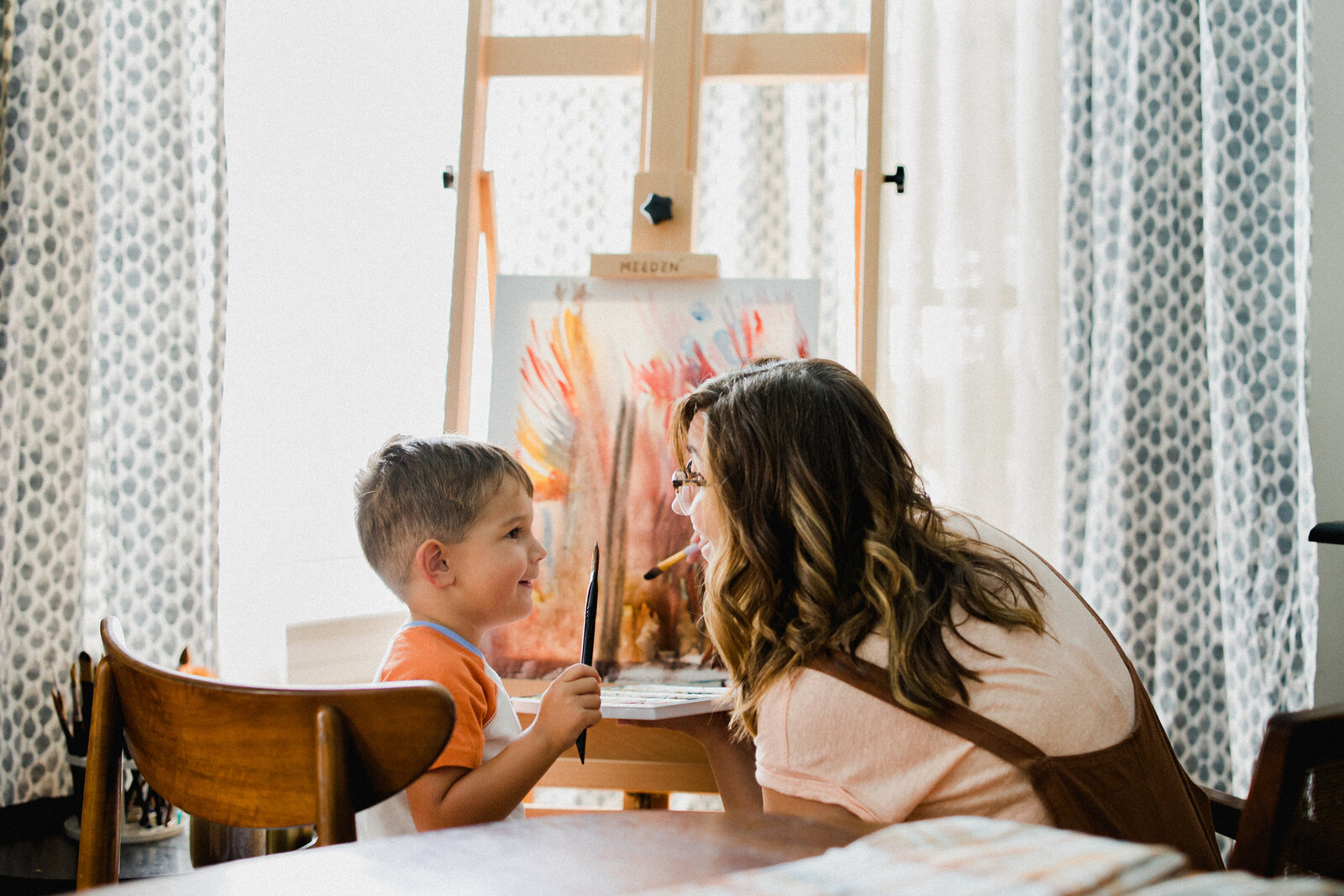 A mom paints with her son during their lifestyle family session in Lakeland