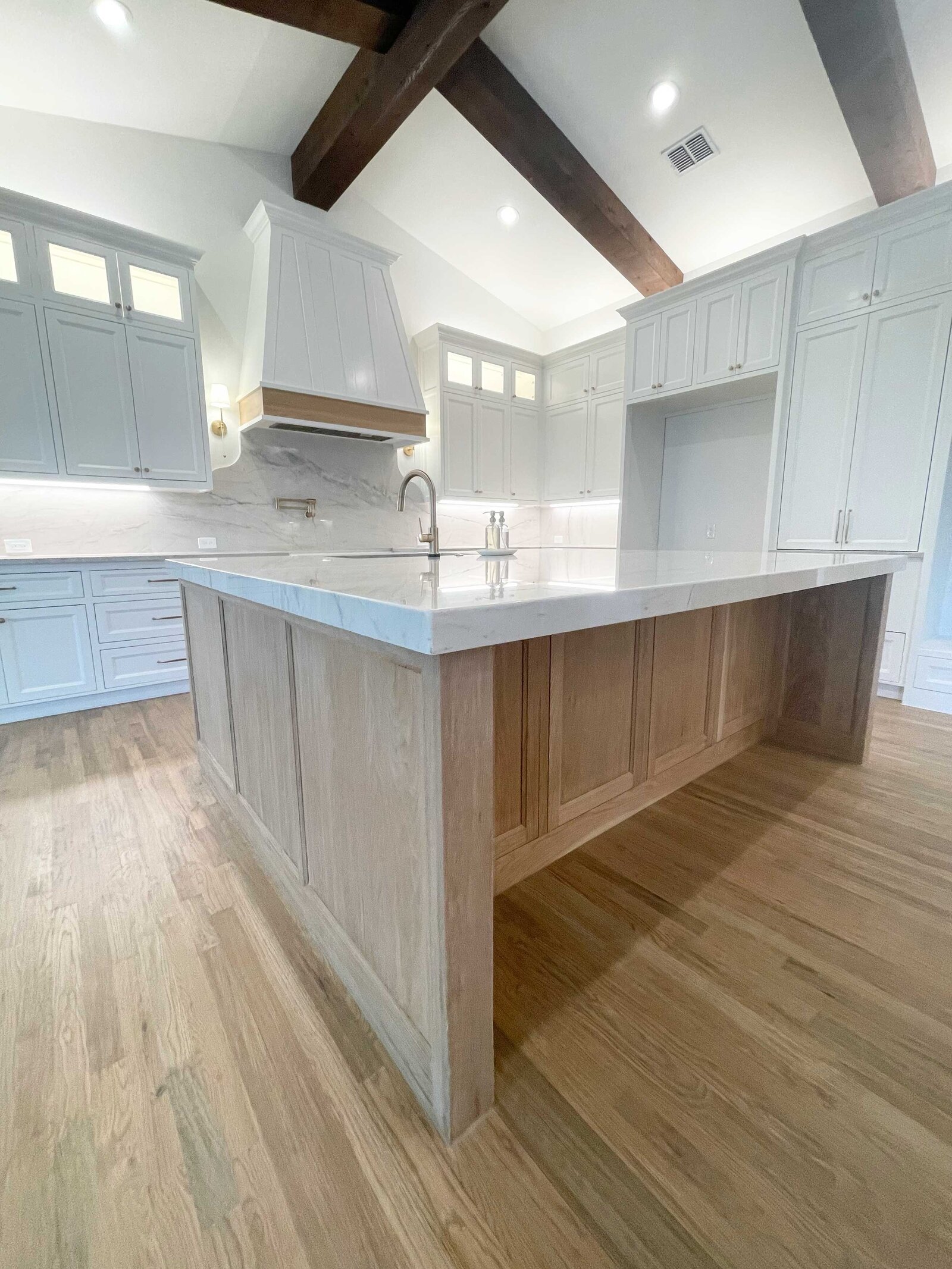 Custom interior design in Frisco TX, featuring a modern kitchen with a wood island table, blending functionality and style in the space.