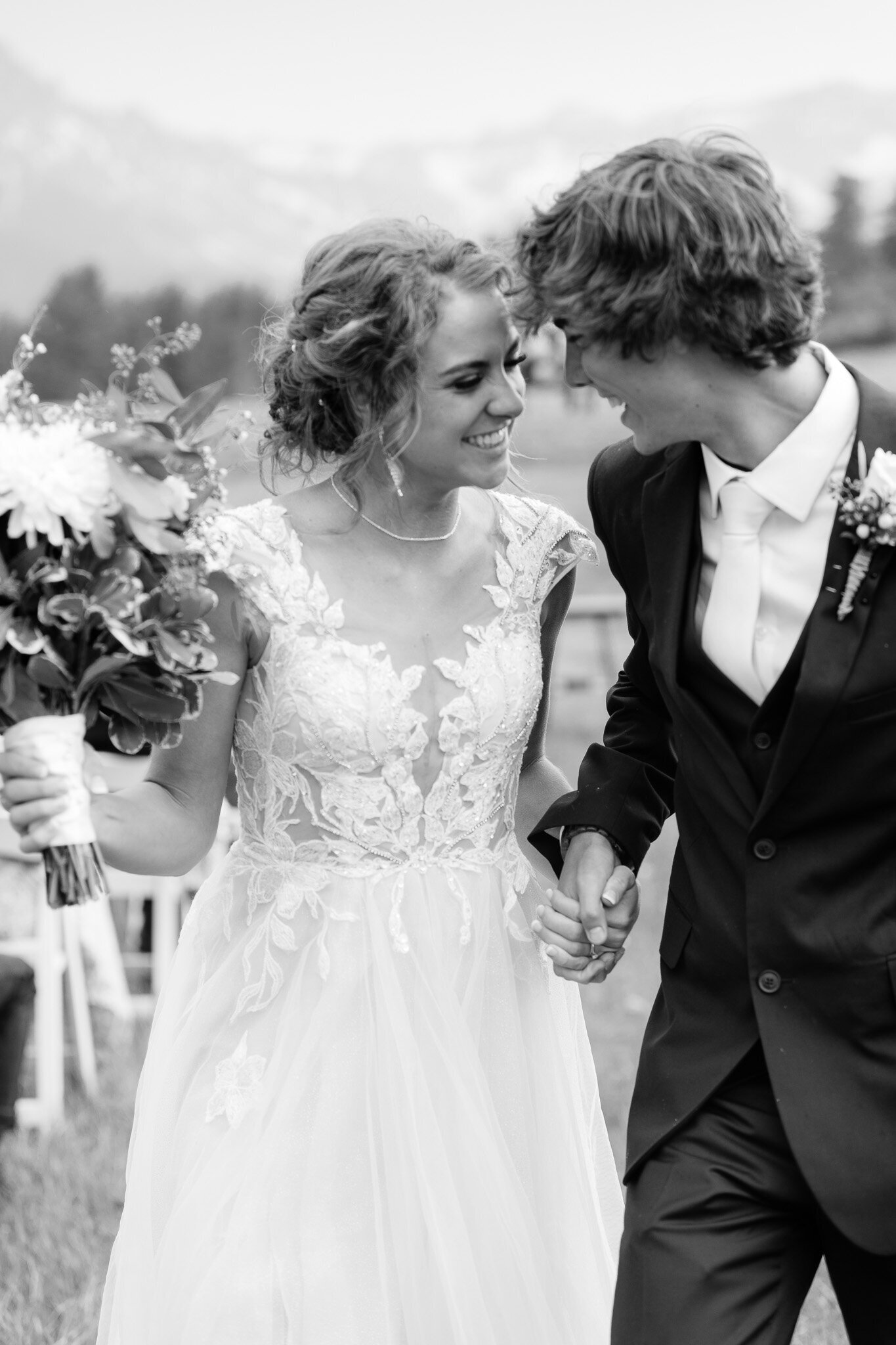 bride and groom smile at each other while leaving the ceremony