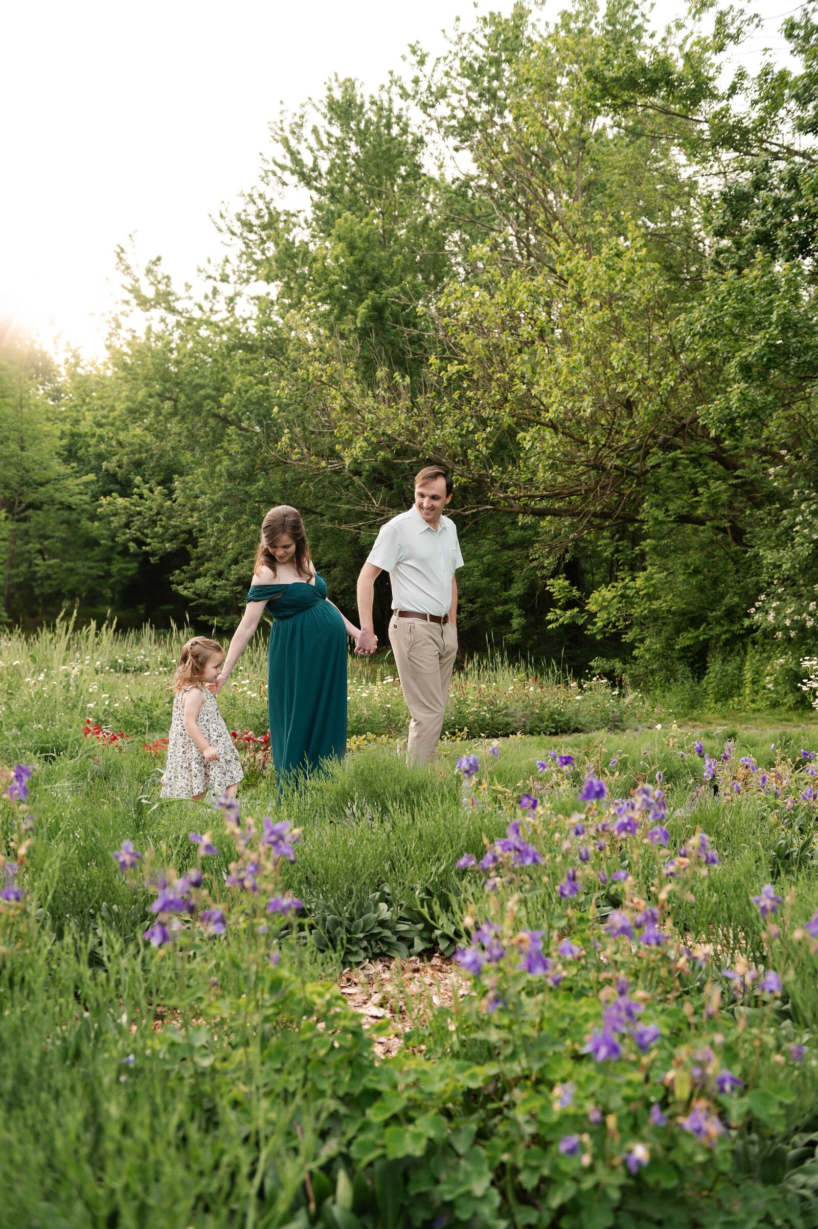 family holding hand while walking in a flower field