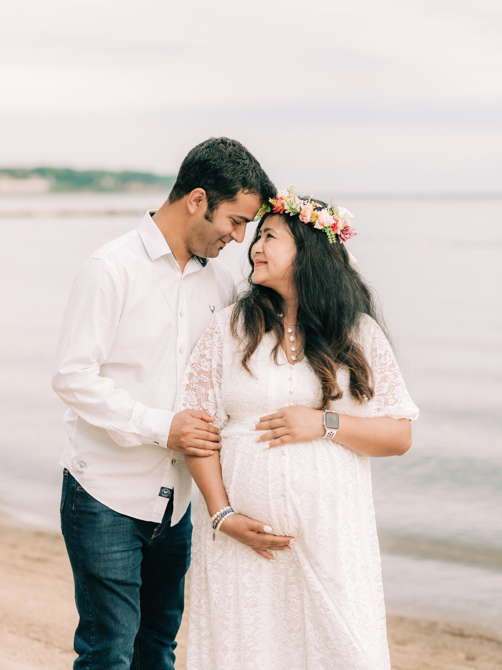 husband and pregnant wife standing on beach for maternity photos Cleveland maternity photographer