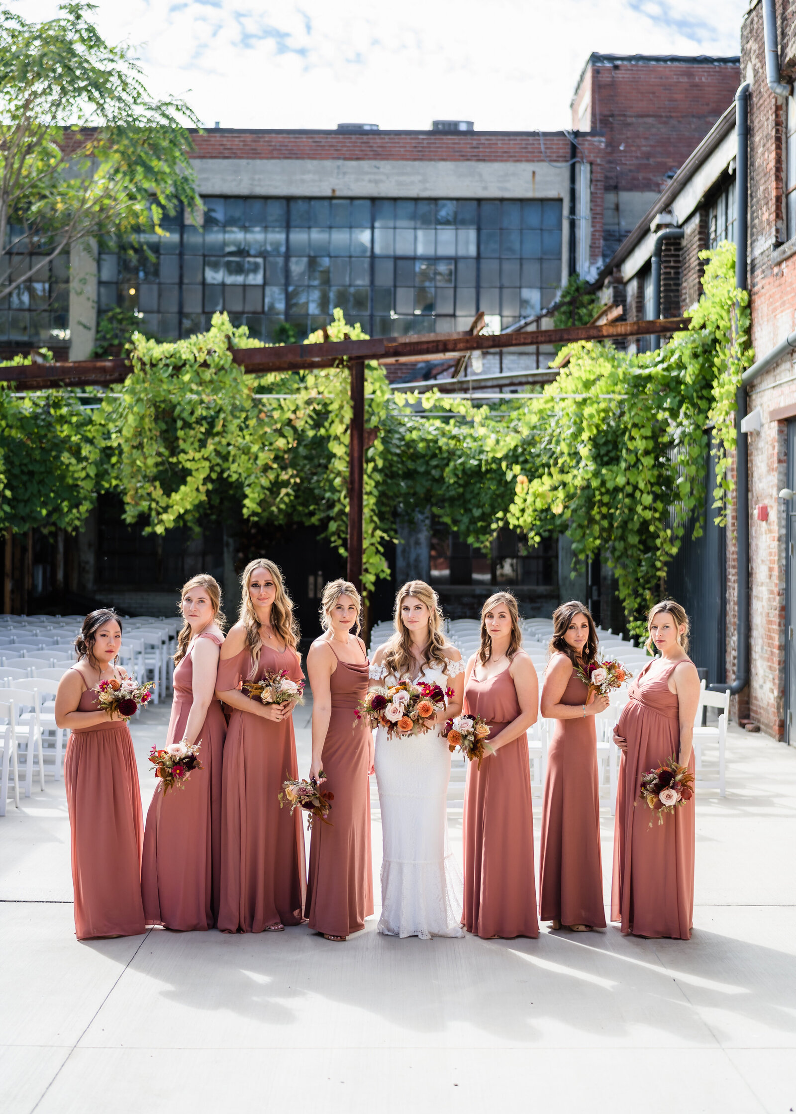The bride and her bridesmaids pose in the courtyard at Strongwater