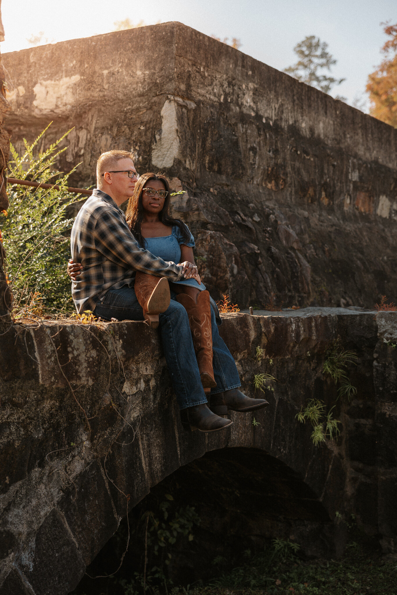Couples session at Savannah Rapids in Evans GA - couple sitting together on the stone bridge during the morning hours.