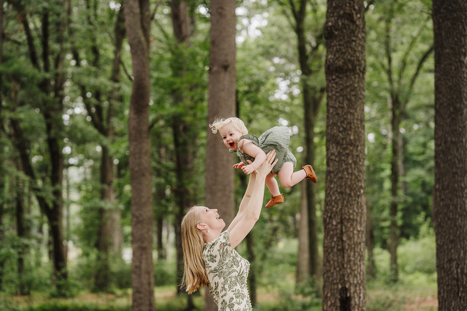mom throws baby in air in the woods for boston family photos