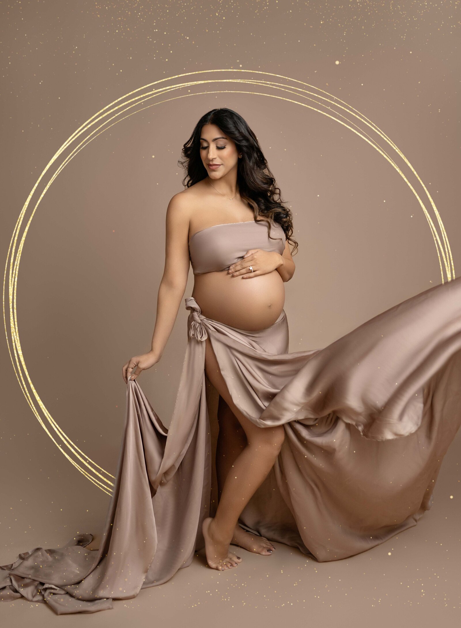 Maternity photo of Mom tossing drape and holding baby bump. Photo taken at Atlanta maternity studio.