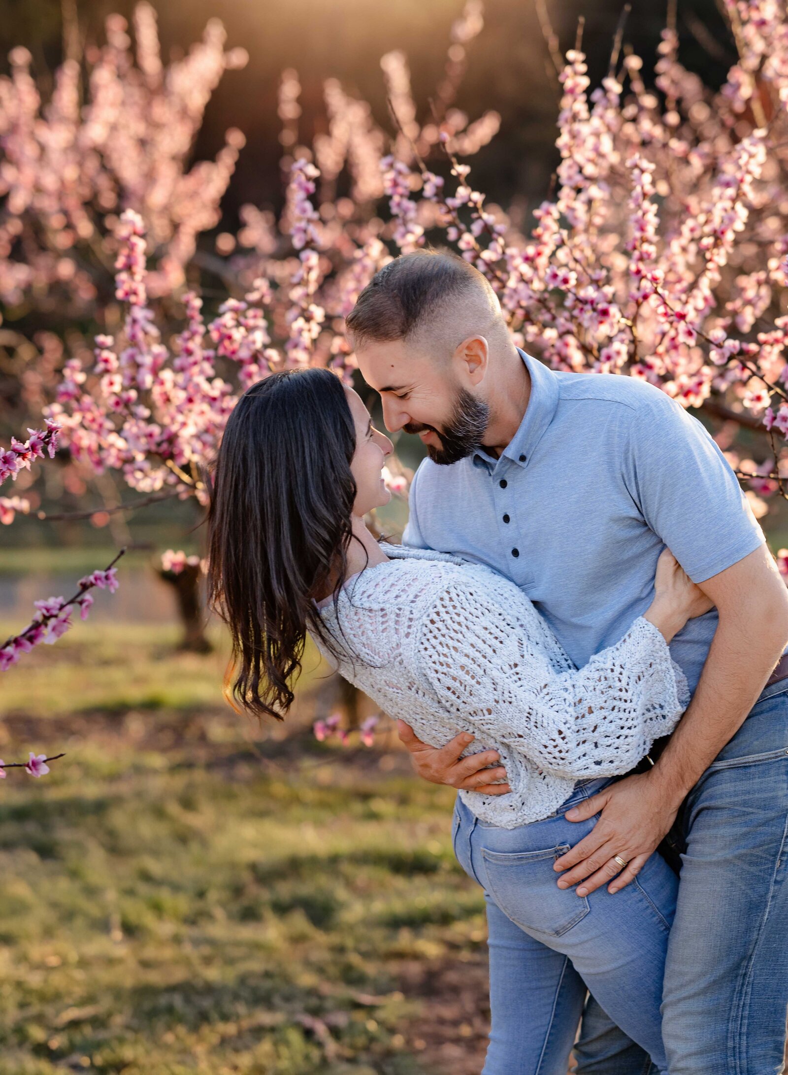 Cherry blossom tree with man dipping women. Couple photo taken by Jenni Nikki Photography near Atlanta, GA.