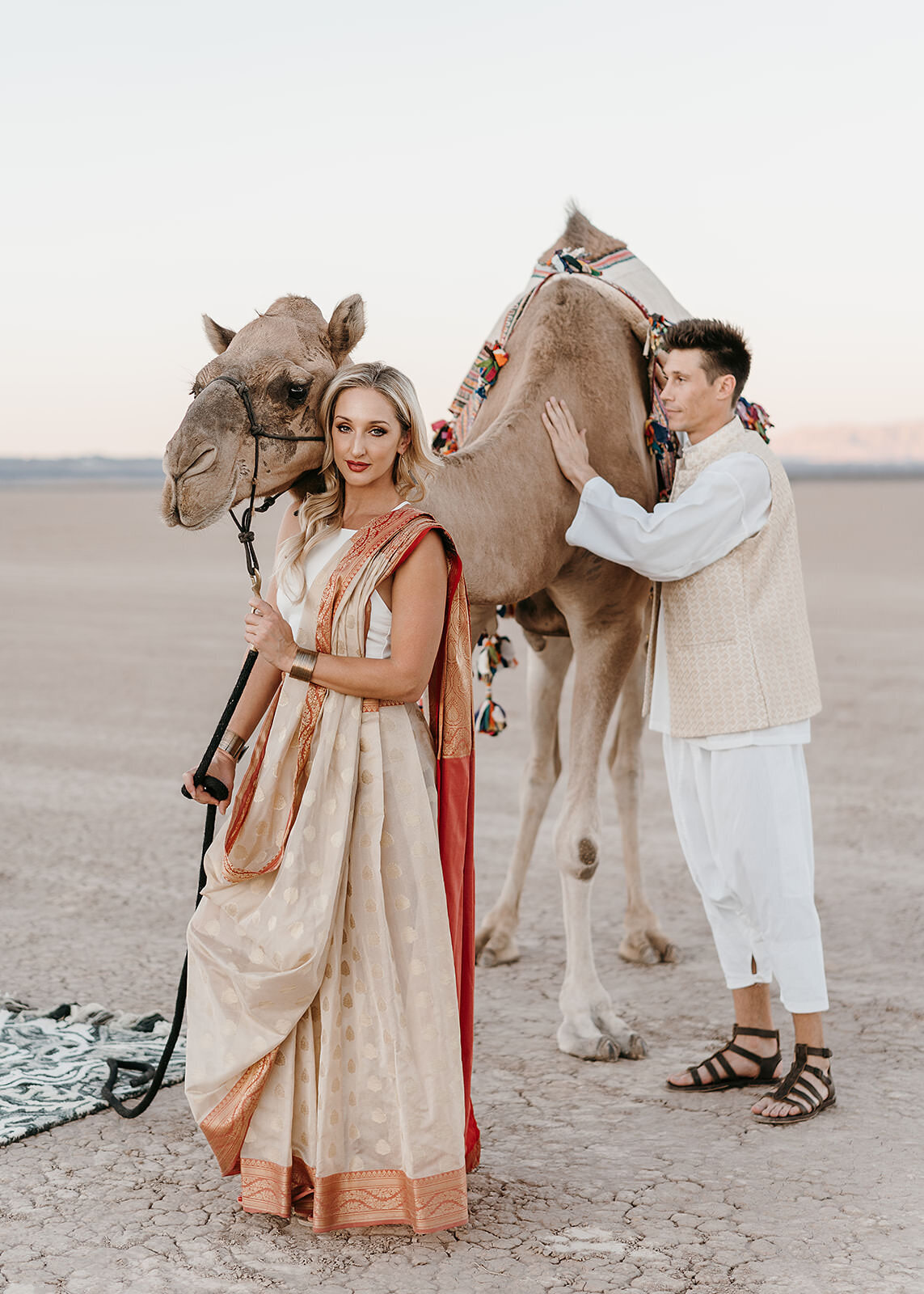 Bride and groom posing with a camel in cultural attire
