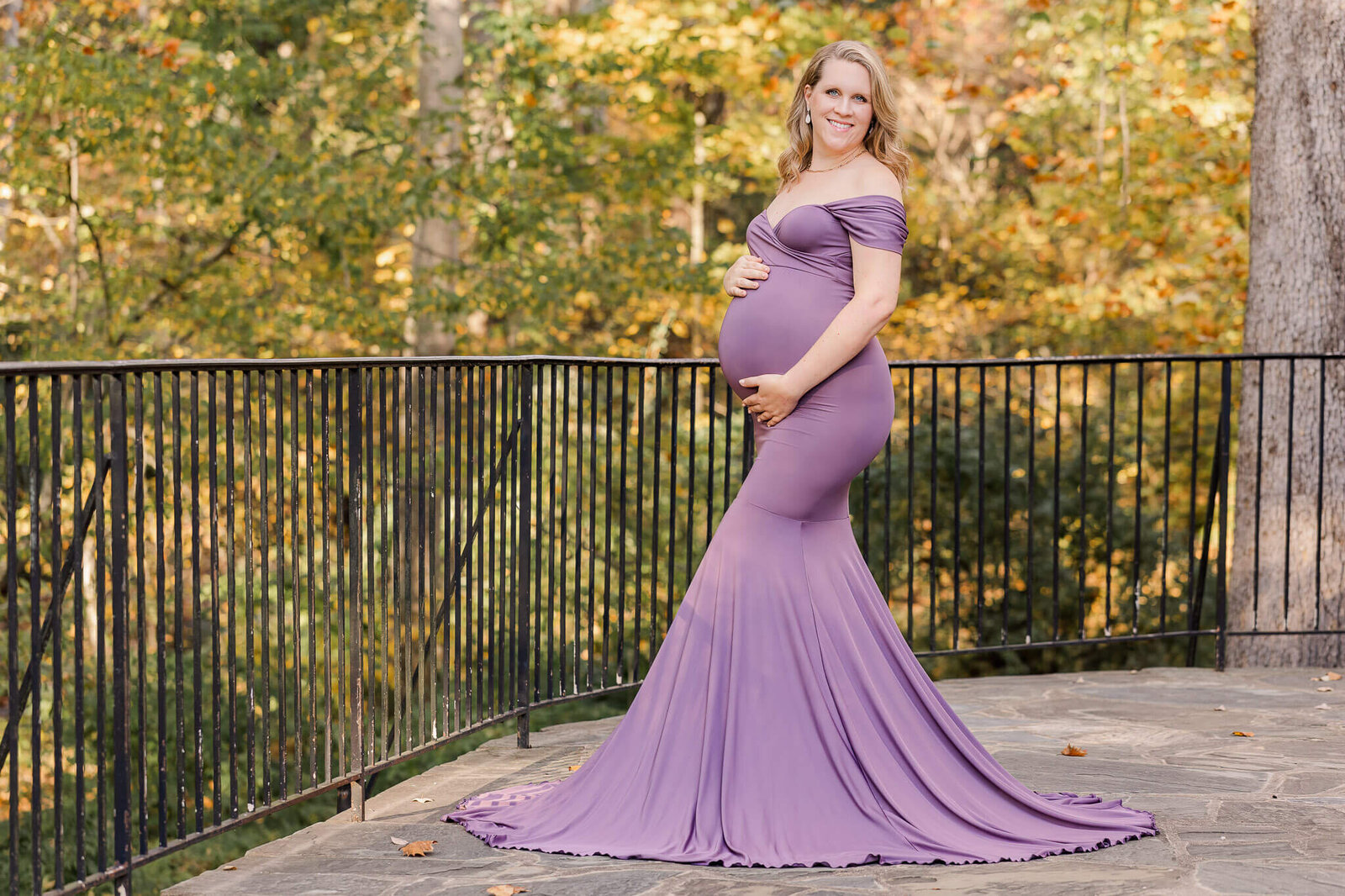 A maternity photo of a woman in a purple dress in a park in Northern Virginia.