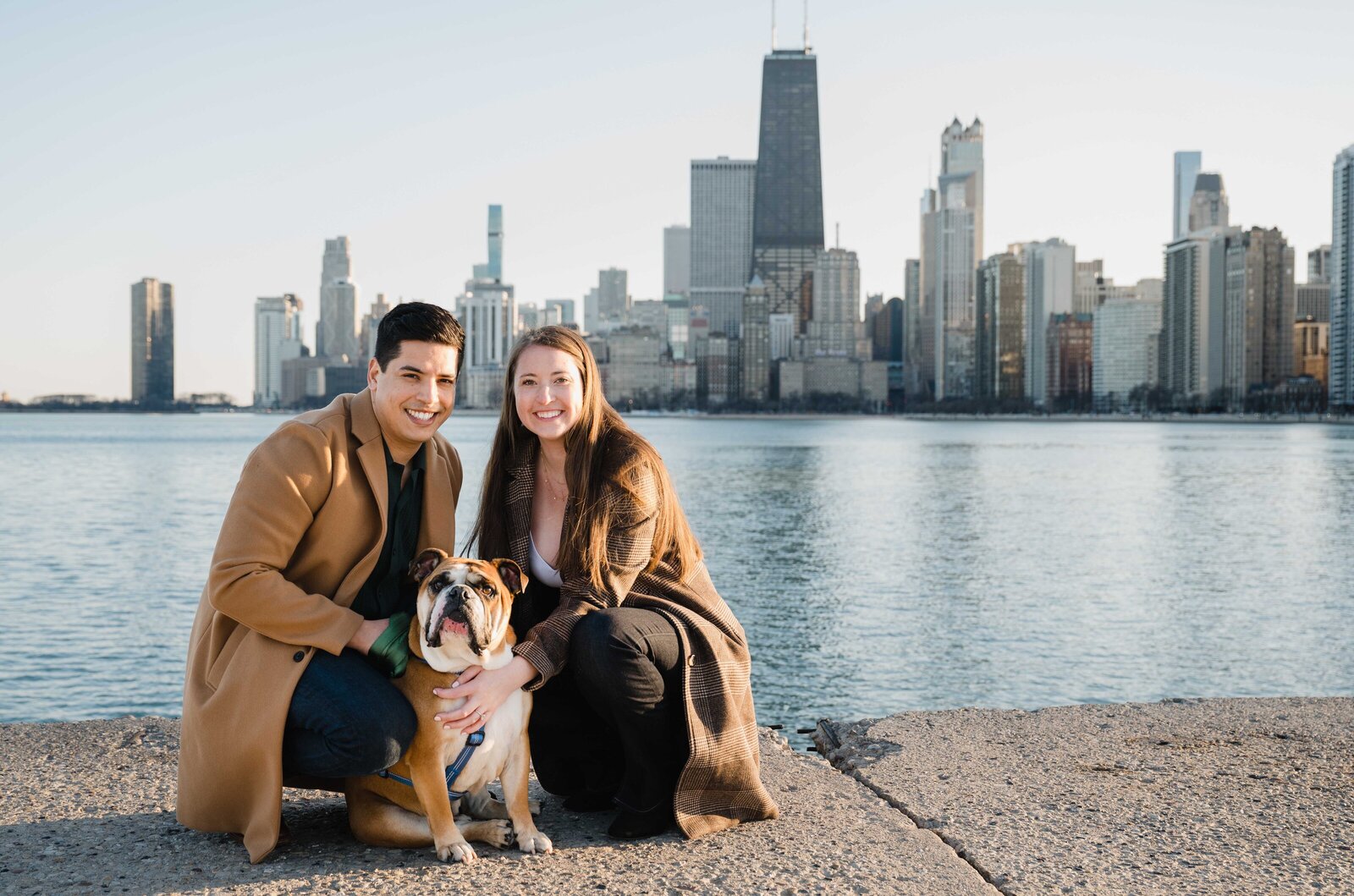 Chicago skyline behind couple with dog on north shore beach