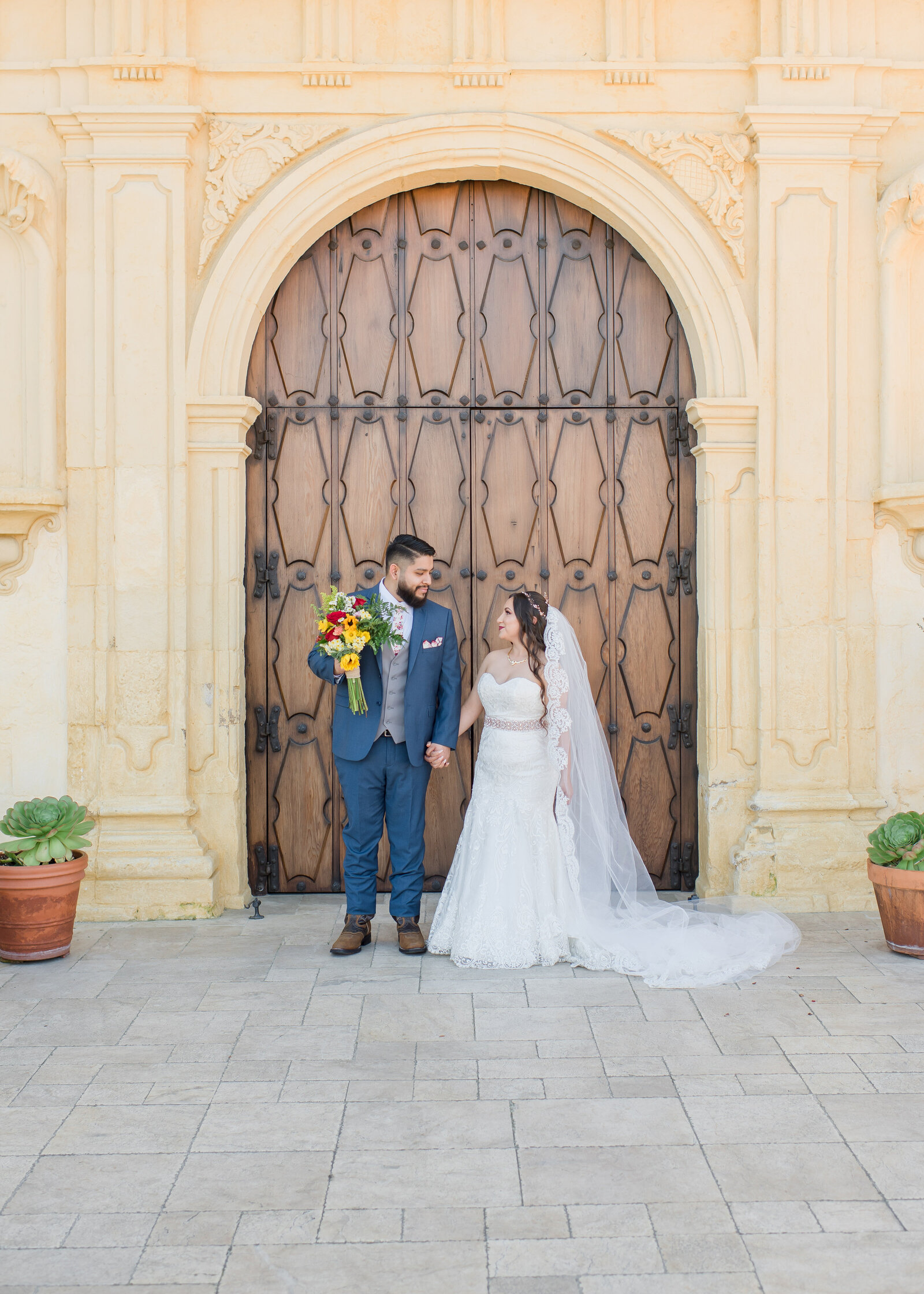 wedding couple holding hands in front of del monte church wedding in monterey
