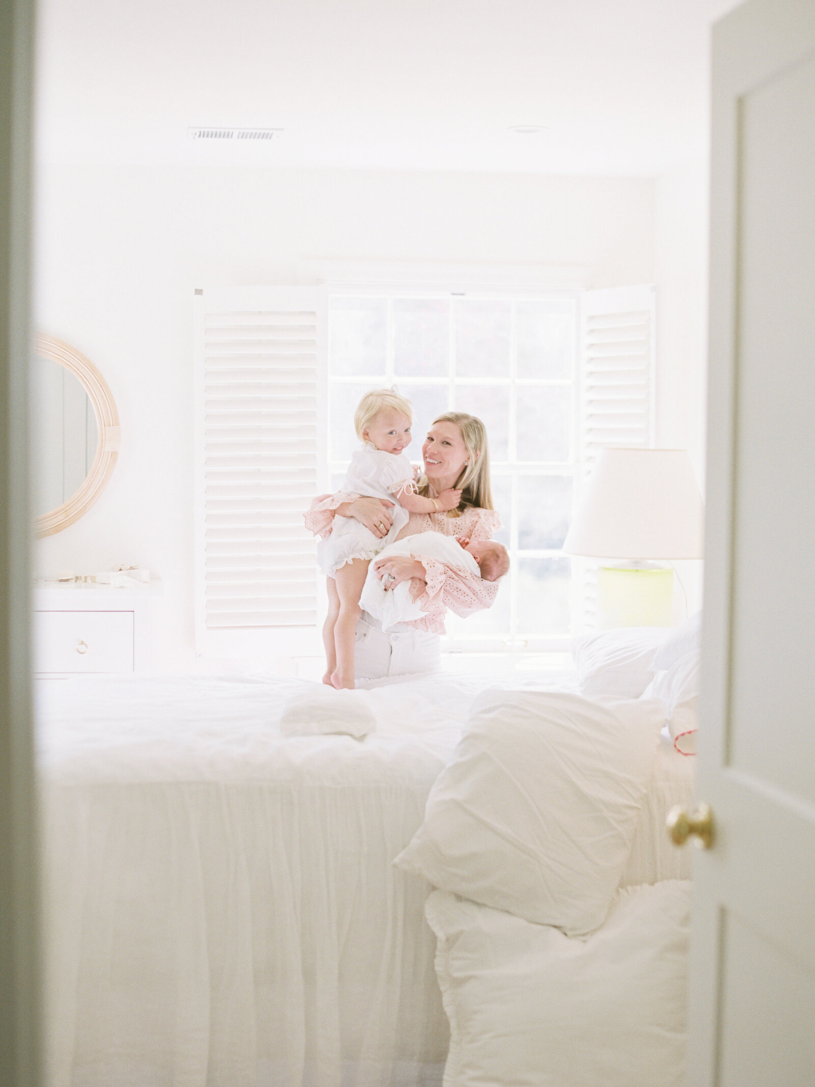 Family photograph with mom holding baby and hugging child