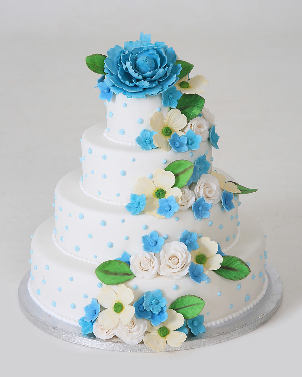 Bruidstaart metblauwe en witte bloemen van Banketbakkerij van den Berg