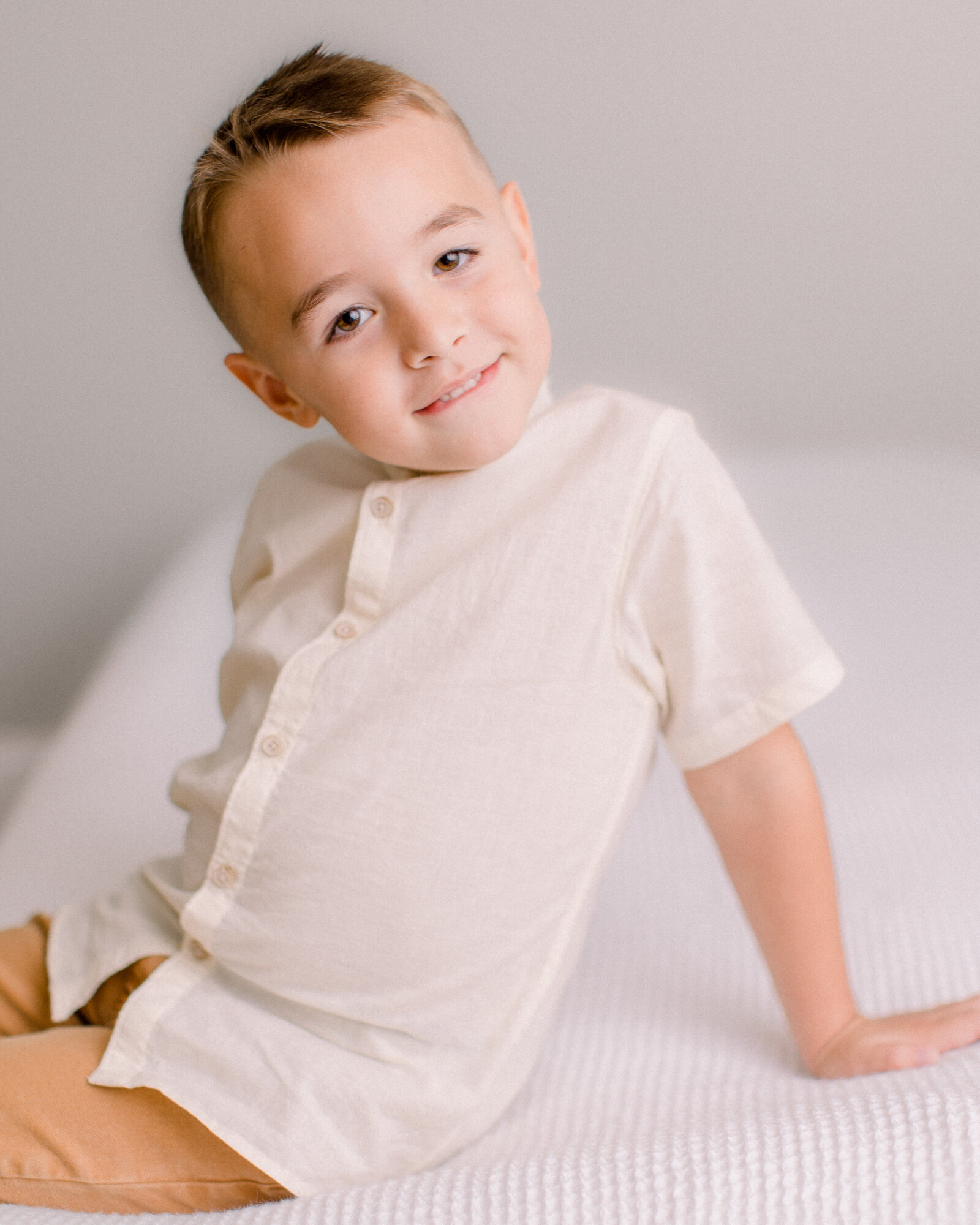 6 year old boy sitting in a neutral studio by NH newborn photographer Fieldstone Studio.