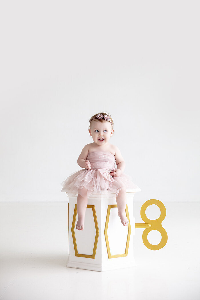 Baby sitting on Ballerina stand.