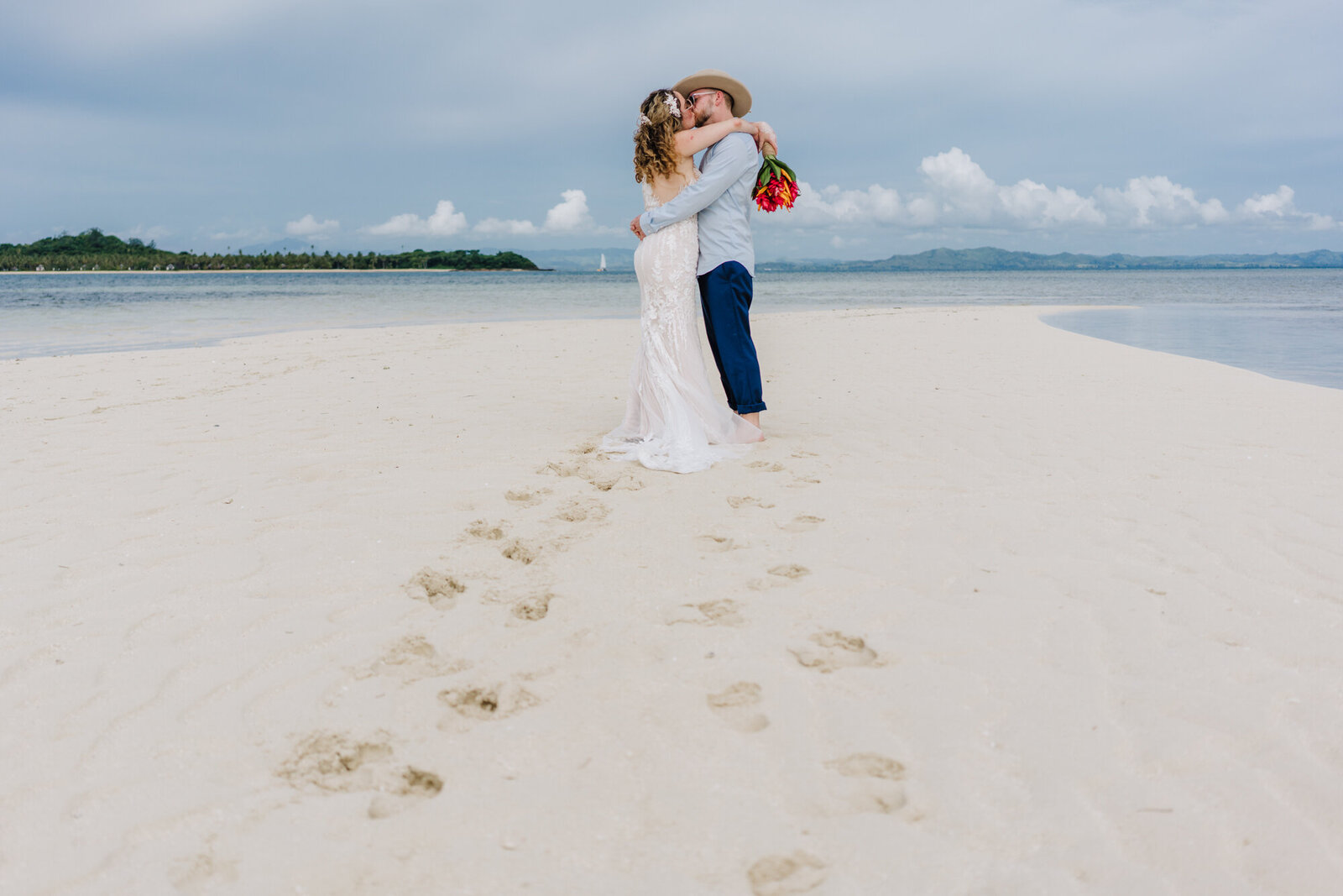 footprints leading to a kissing couple