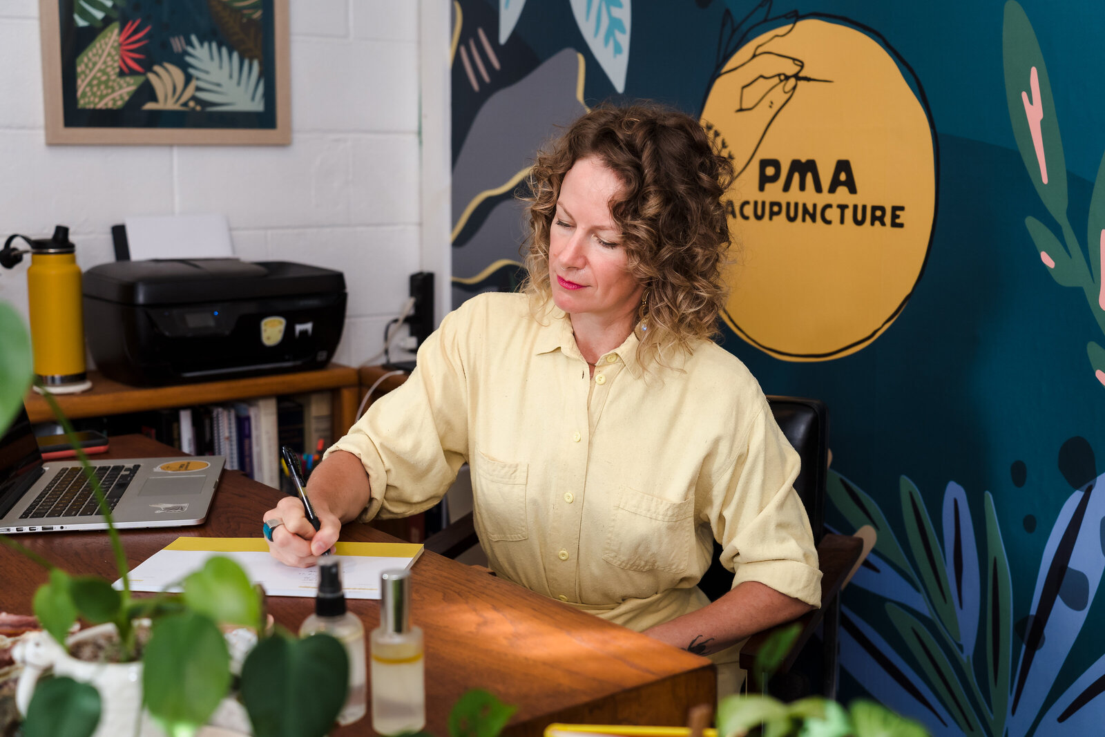 small business owner seated in her desk, and takes notes
