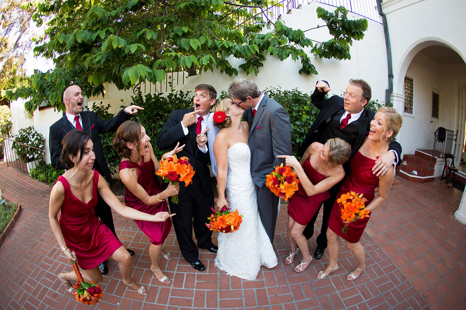 bridal party with orange flowers and red dresses