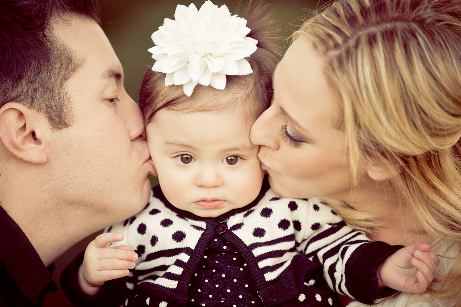 san diego family photographer | mom and dad kissing daughters cheeks
