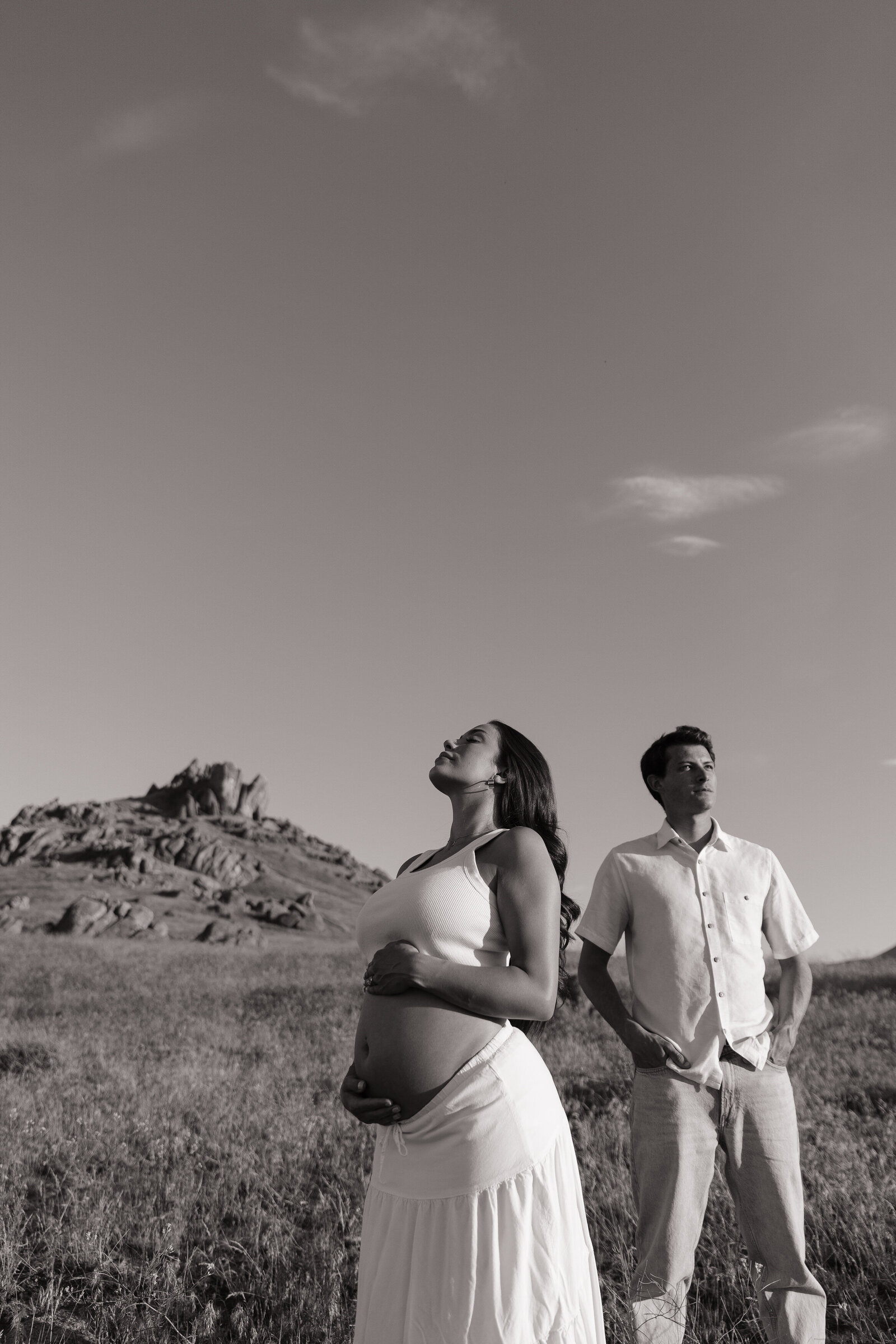 Golden hour maternity portraits of mother and father in mountain clearing