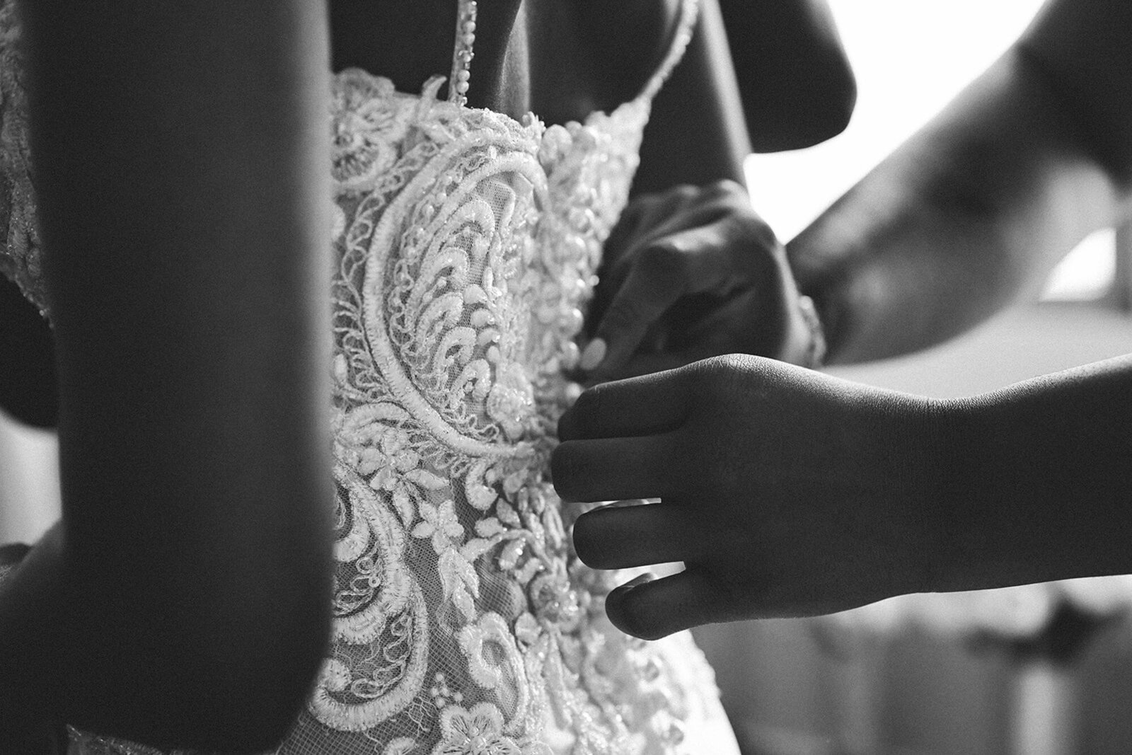 bride getting her wedding dress buttoned up
