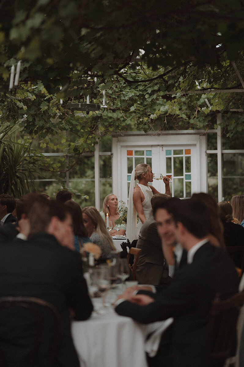 Bruden dricker vin i bröllopsmiddagen