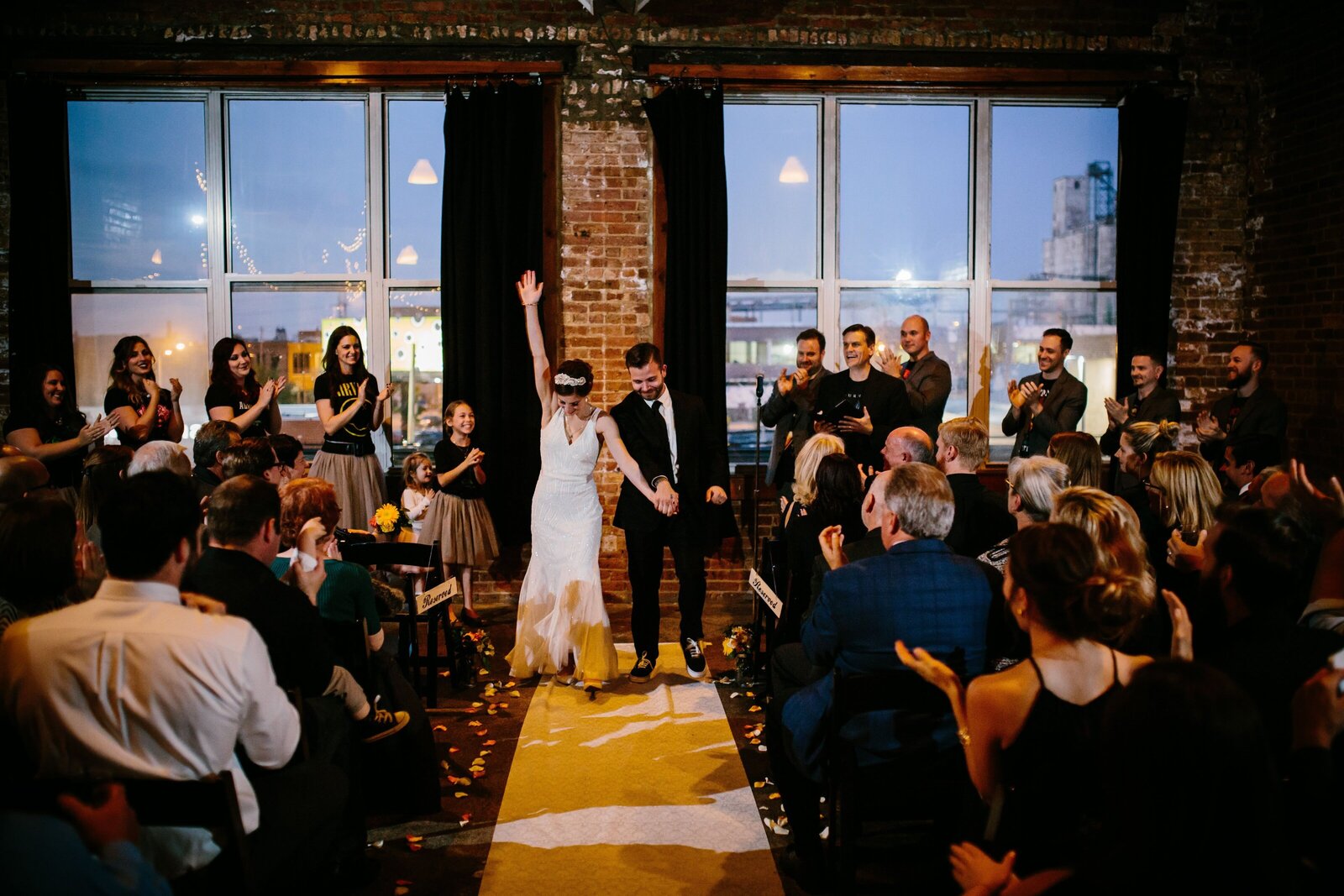 Bride and groom raise their arms and cheer after taking their wedding vows