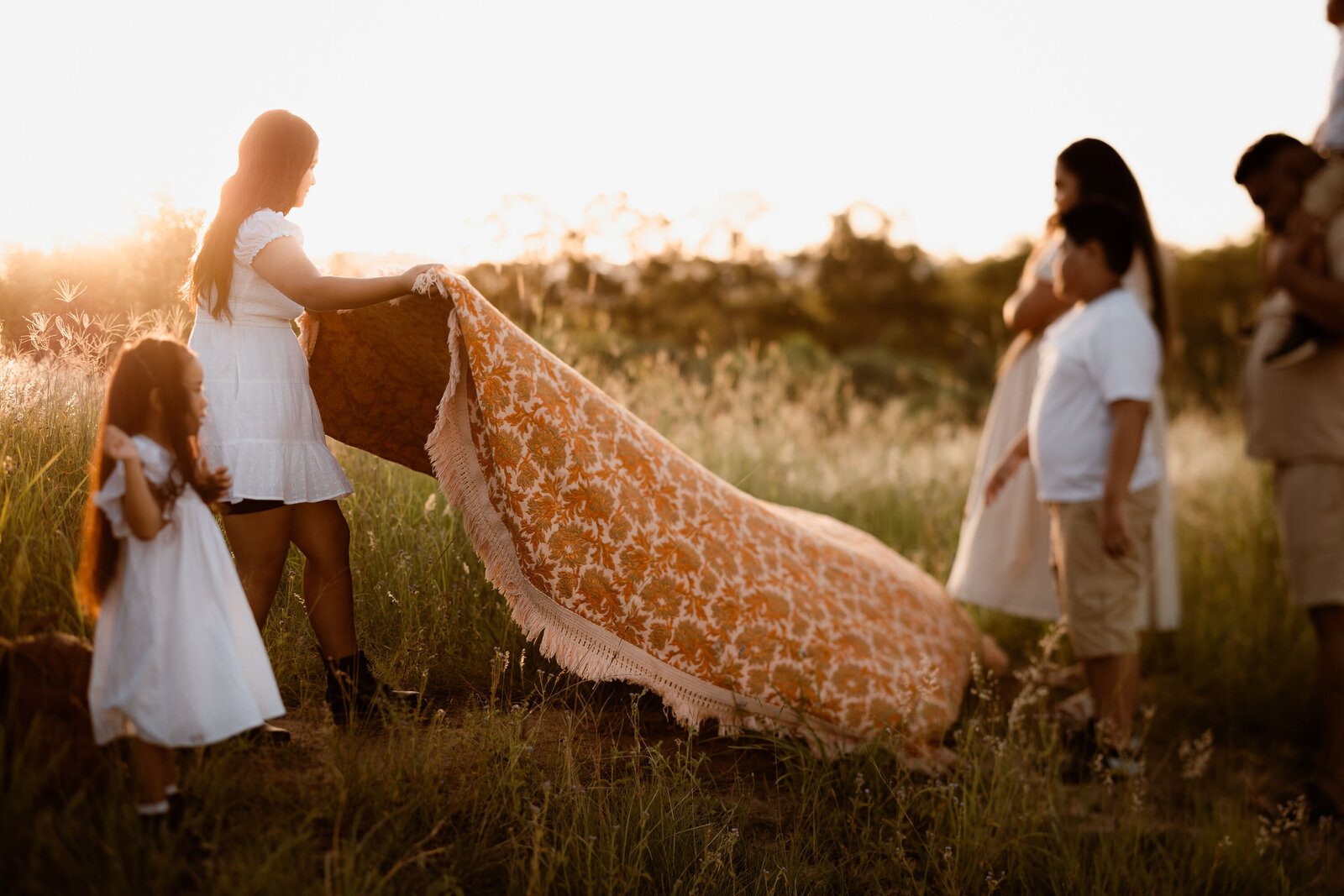 big picnic blanket, family photos in ipswich at a beautiful outdoor location surrounded by trees and long grass
