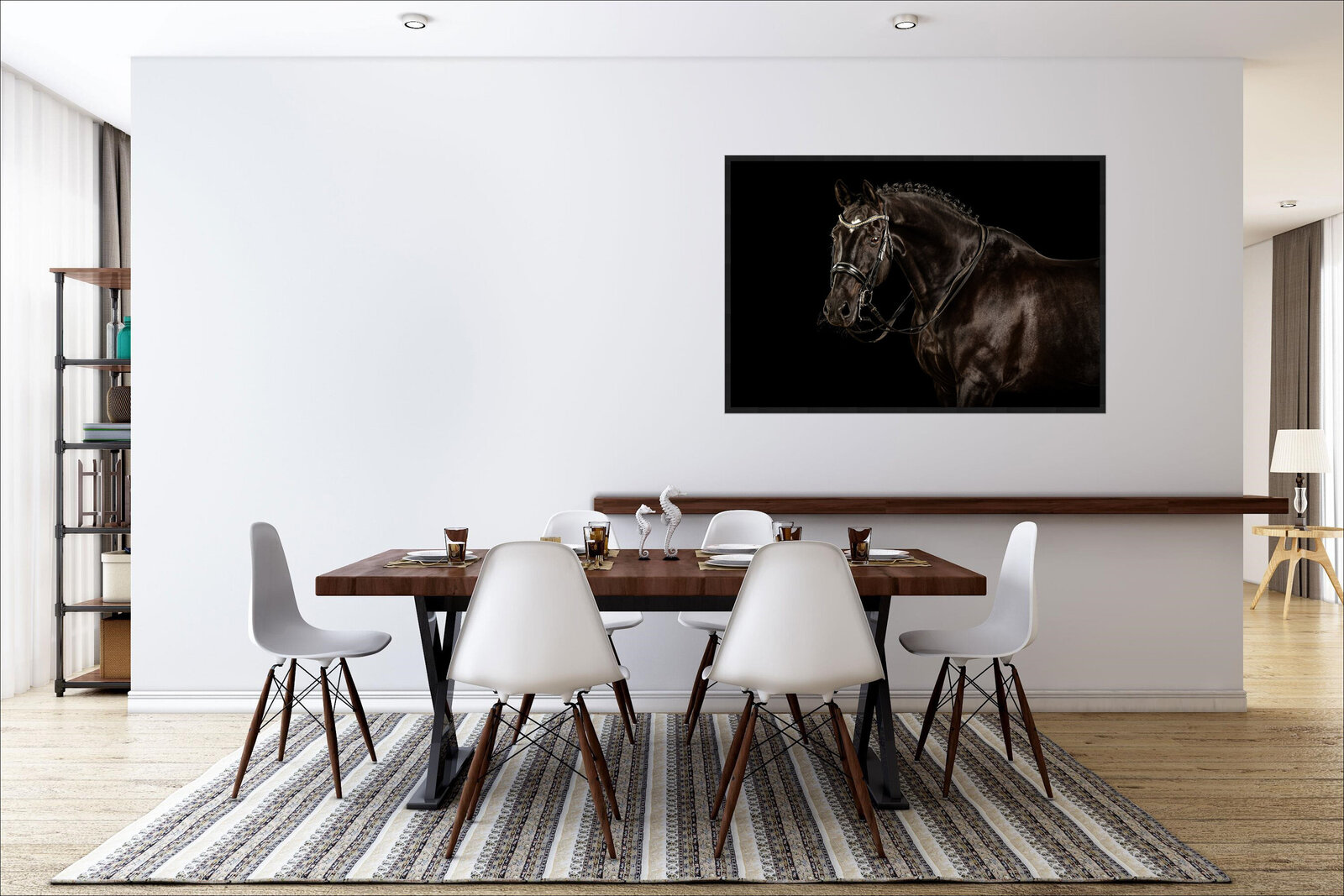 A dining room with a white wall and a portrait of a black horse with double bridle hanging on the wall over the dining table