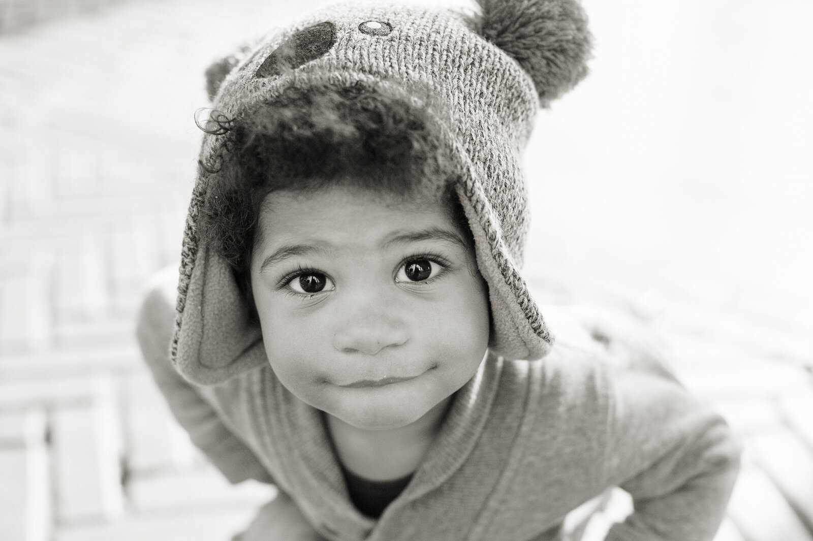 A small child smiling in a koala beanie 