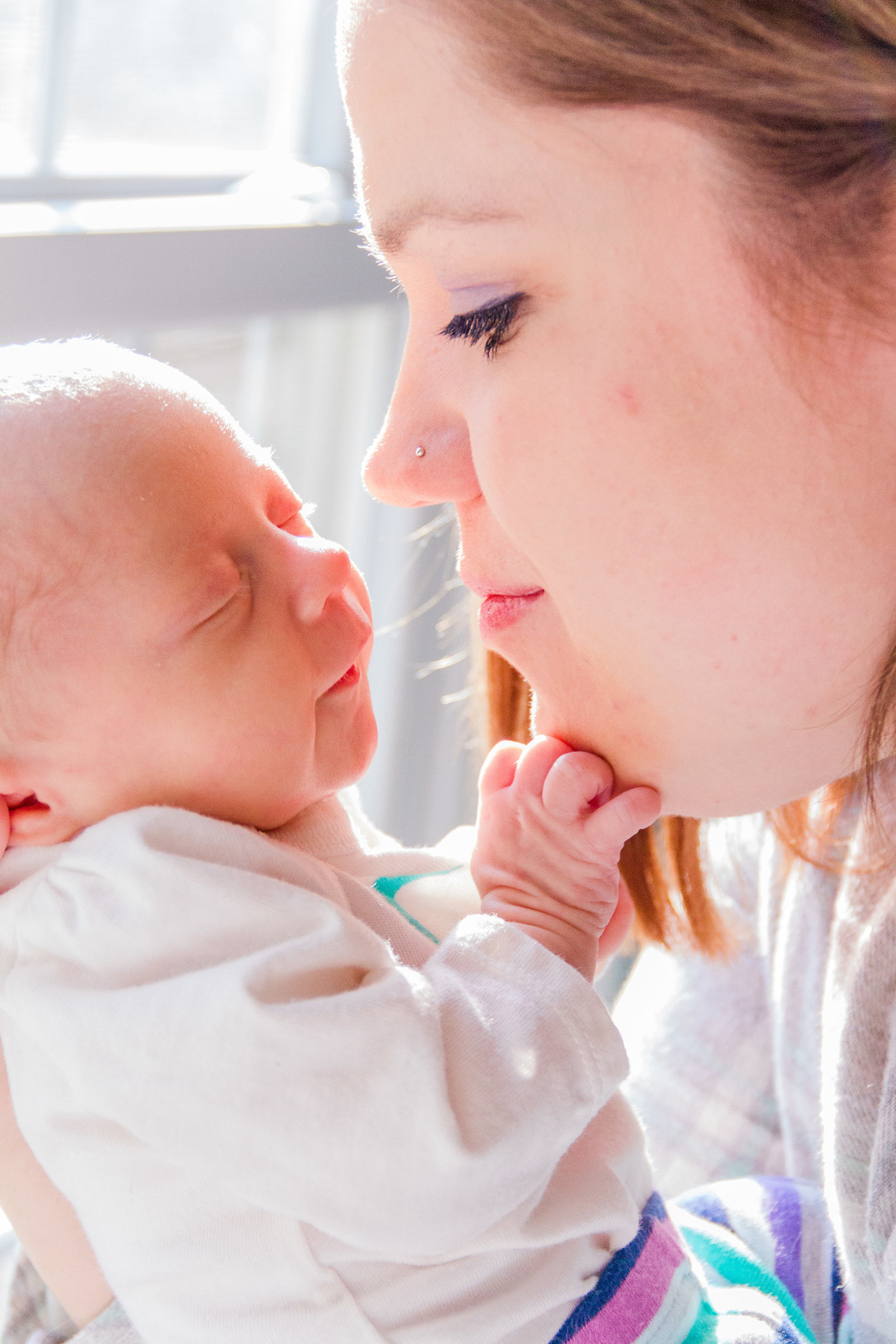 Newborn infant and mother touch noses