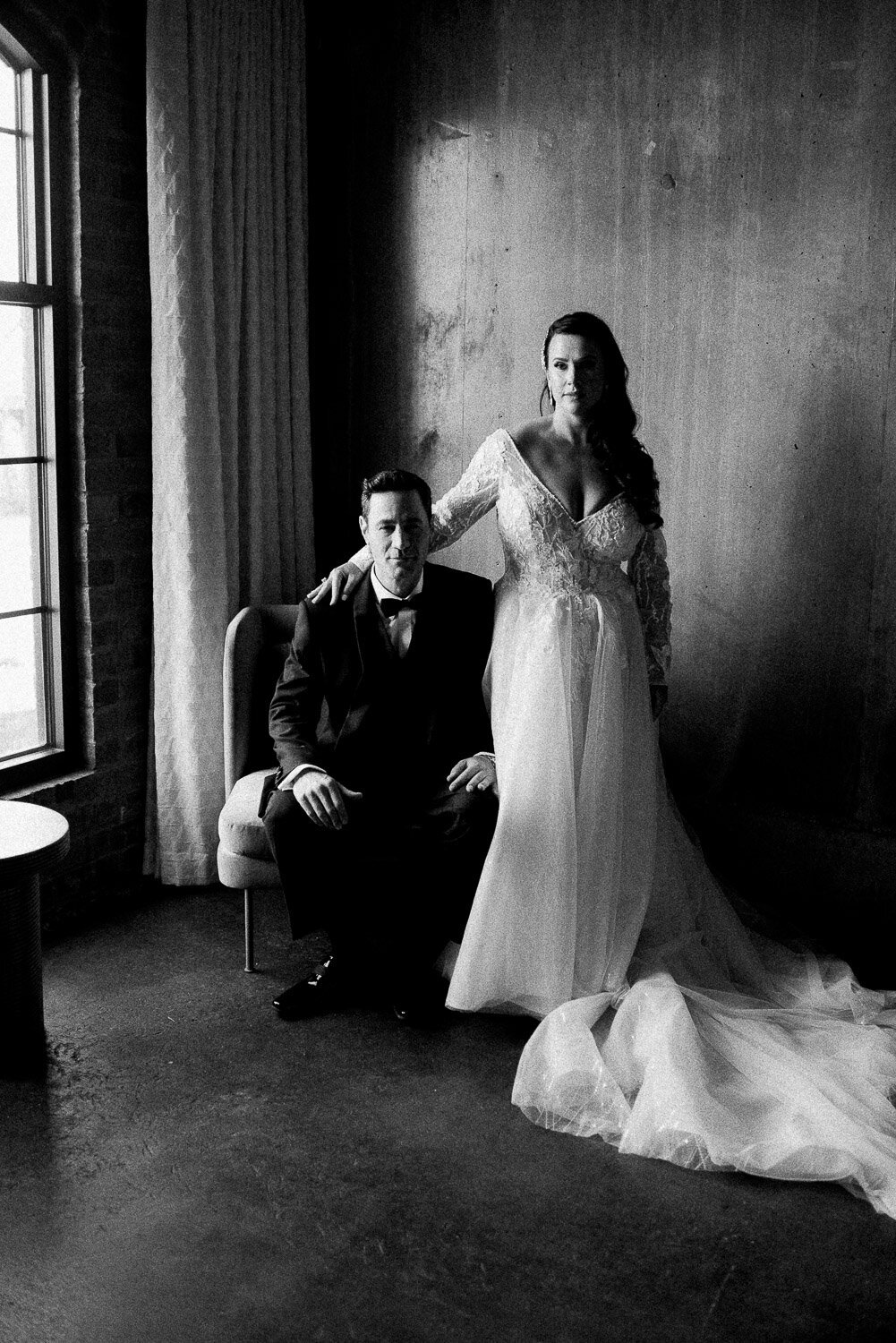serious dramatic couple portrait bride stand groom sit