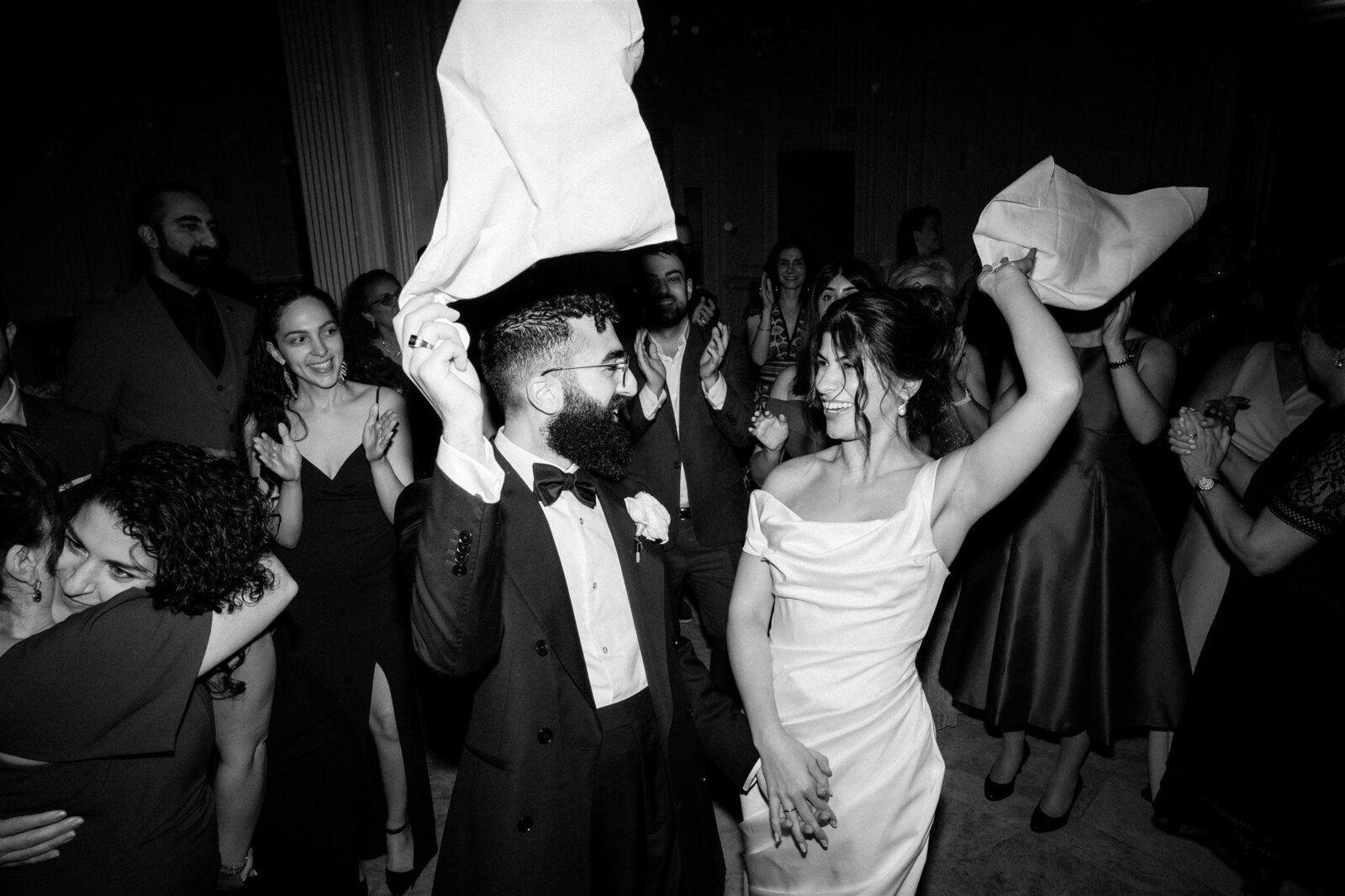 bride, groom and guests dancing with napkins in the air at andaz hotel wedding party