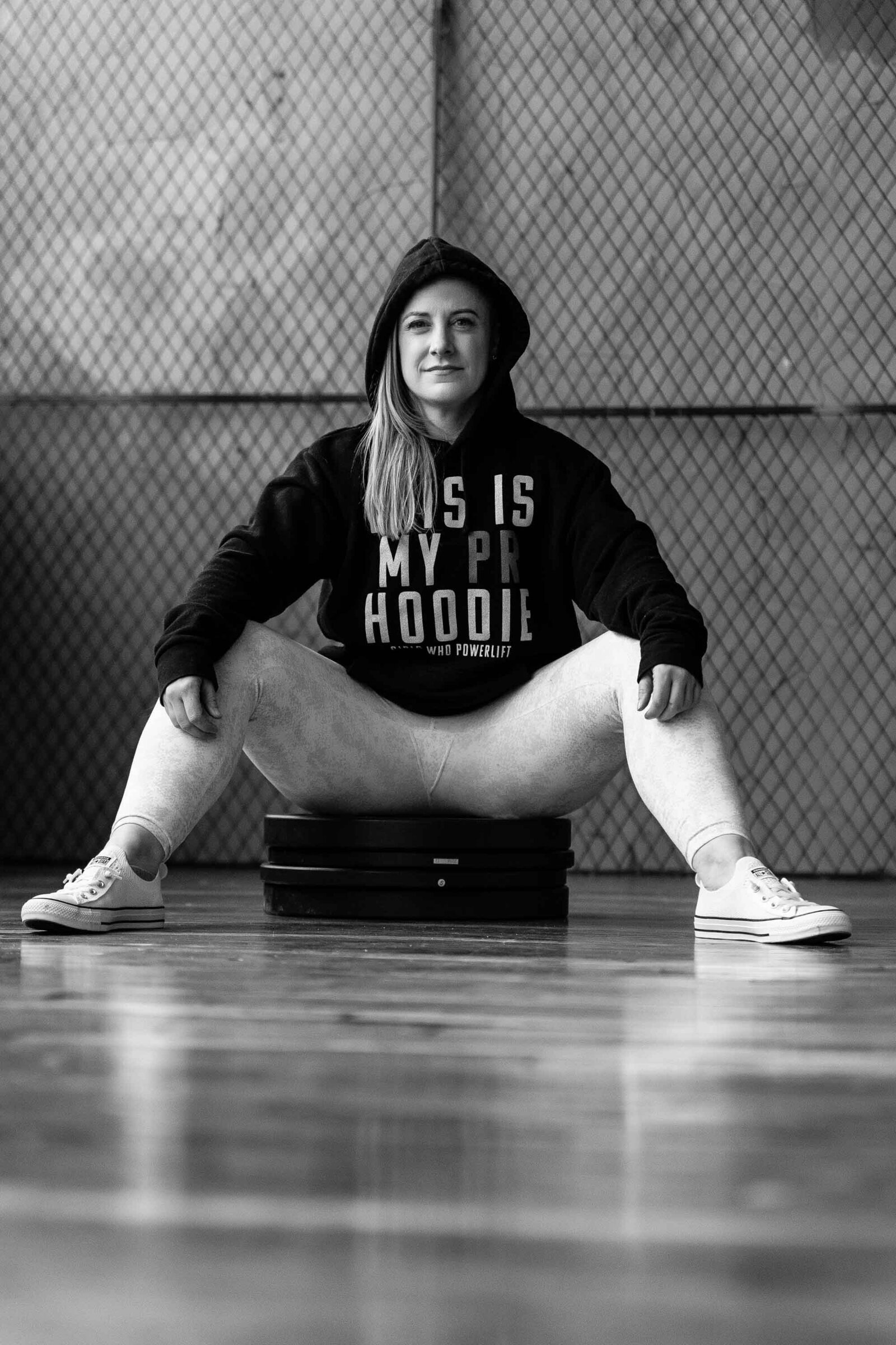 black and white photo of a woman sitting on weights