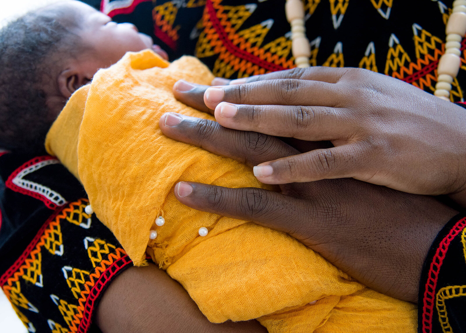 Chicago parents in traditional regalia holding their baby