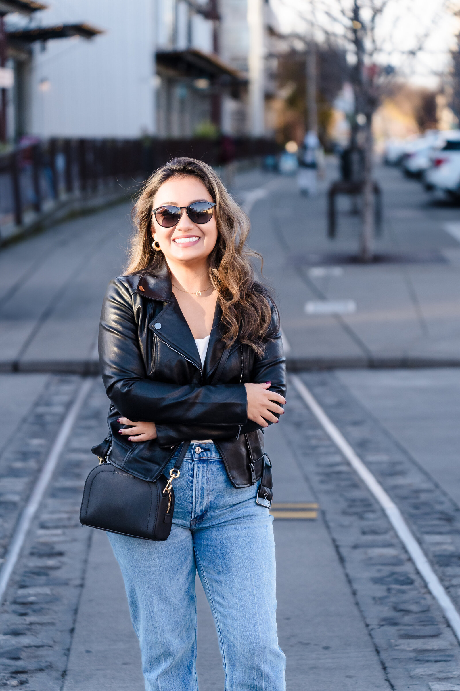 Coach for women in a power pose in the middle of the street during golden hour