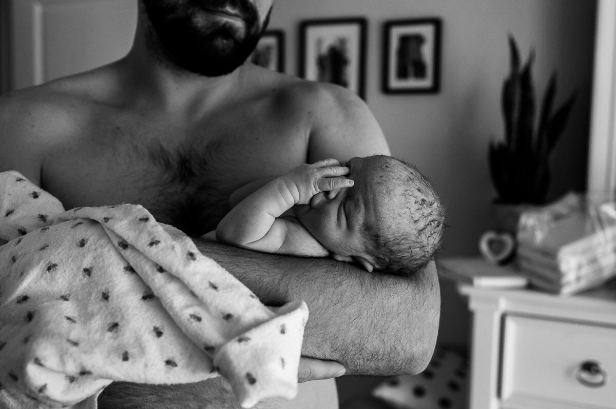 dad holds newborn after homebirth in New Braunfels