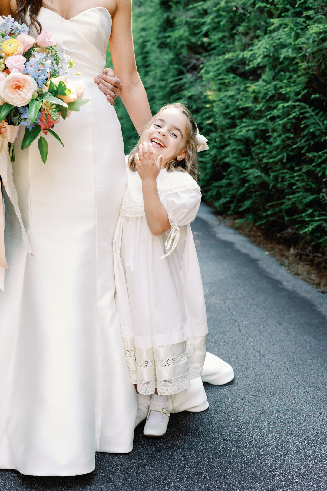 flower girl laughing hugging bride at the farm at old Edwards inn
